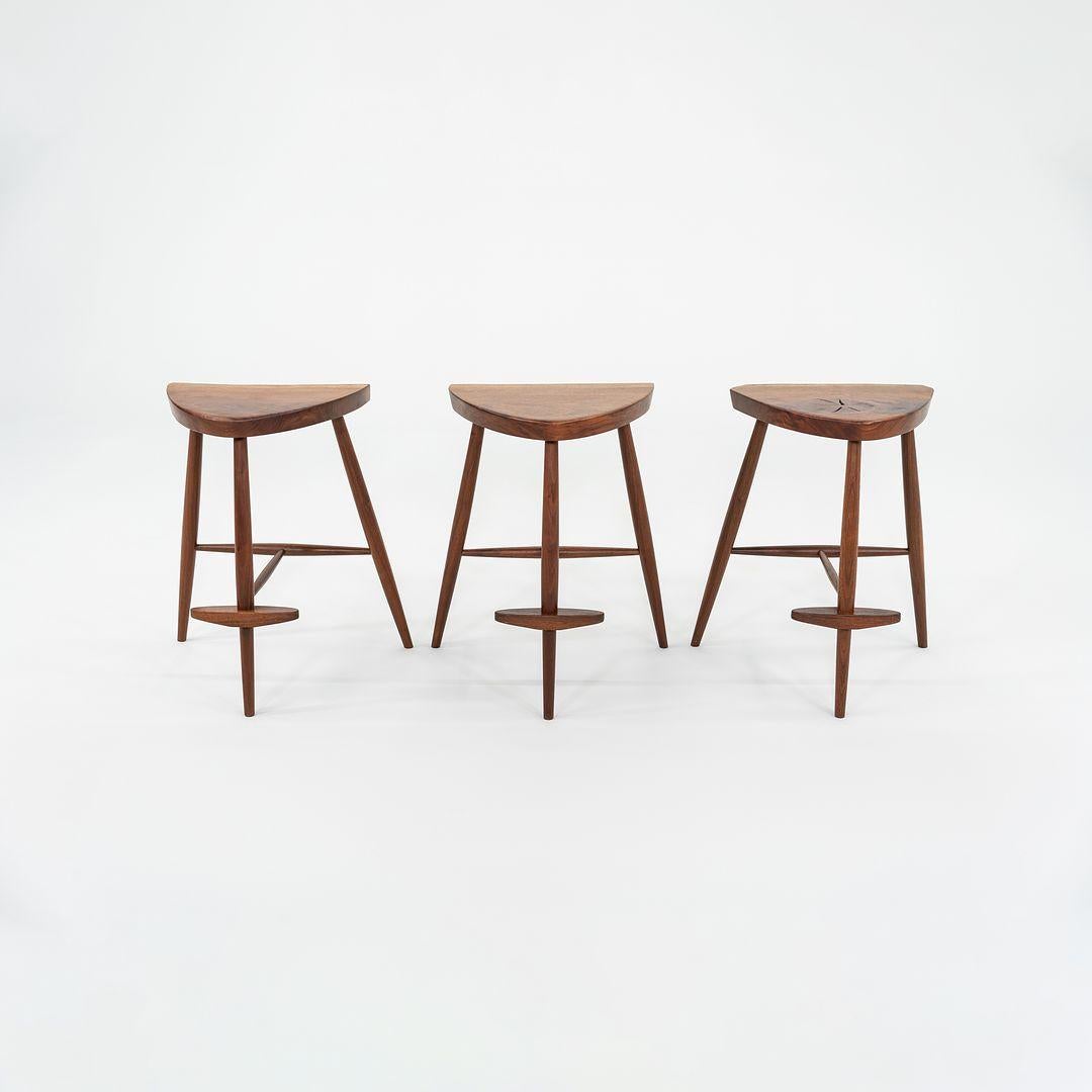 This is a rare set of three American Black Walnut Counter Stools, designed and created by Mira Nakashima for a client in 2001. The wood for these pieces was specially selected in concert with her client, and they were custom sawn by the artist. The