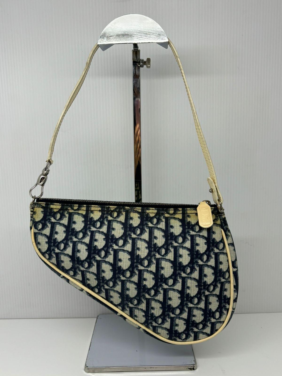 Classic Dior vintage oblique saddle pochette. Item is in fair condition, with visible yellowing on the corners of the bag pvc as seen on the pictures. Handles might need replacing since it’s already cracking. Minor tarnishing throughout as well