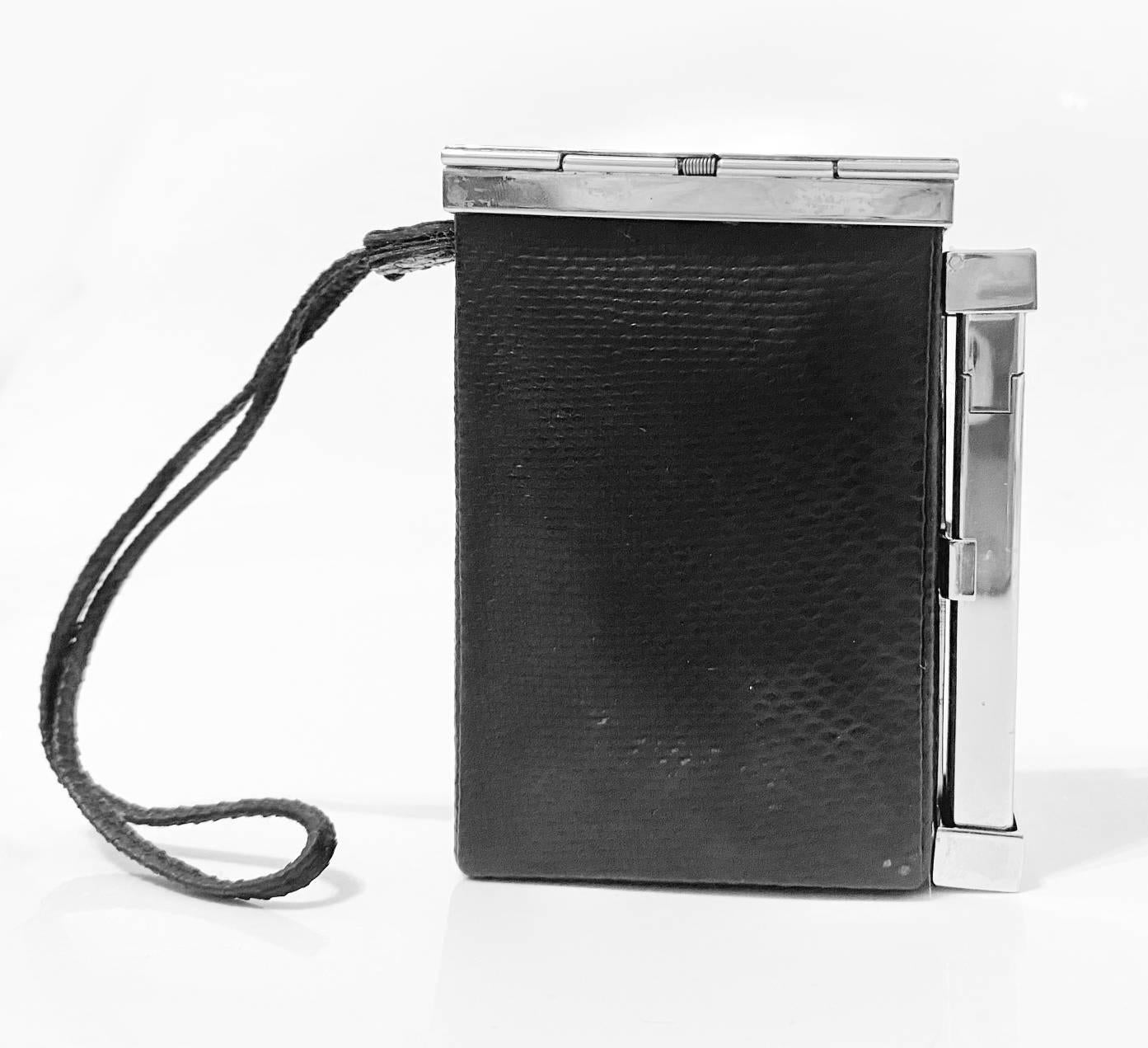 Amazing vintage smoking box and purse from Yves Saint Laurent designed by Tom Ford in 2001. Silver tone metal ware, black shiny fabric, clutch closure with logo details, fully working  lighter with signature on, black fabric string. 

Condition: