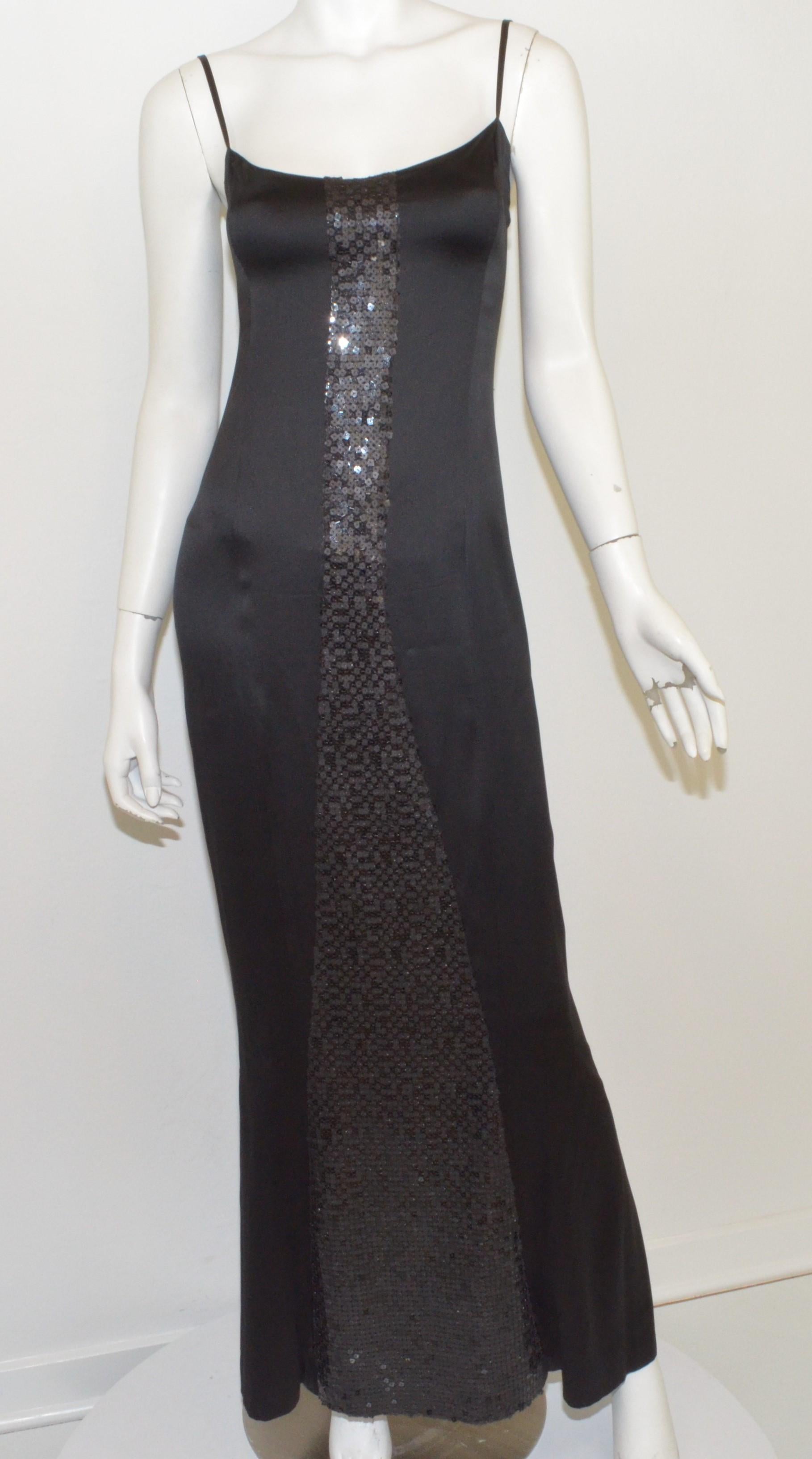 Chanel slip dress featured in black with sequin embellishments along the front and back, flat shoulder straps, and a back zipper fastening. Dress is labeled size 38, made in France. Dress is composed with 100% rayon and a 100% silk double lining.