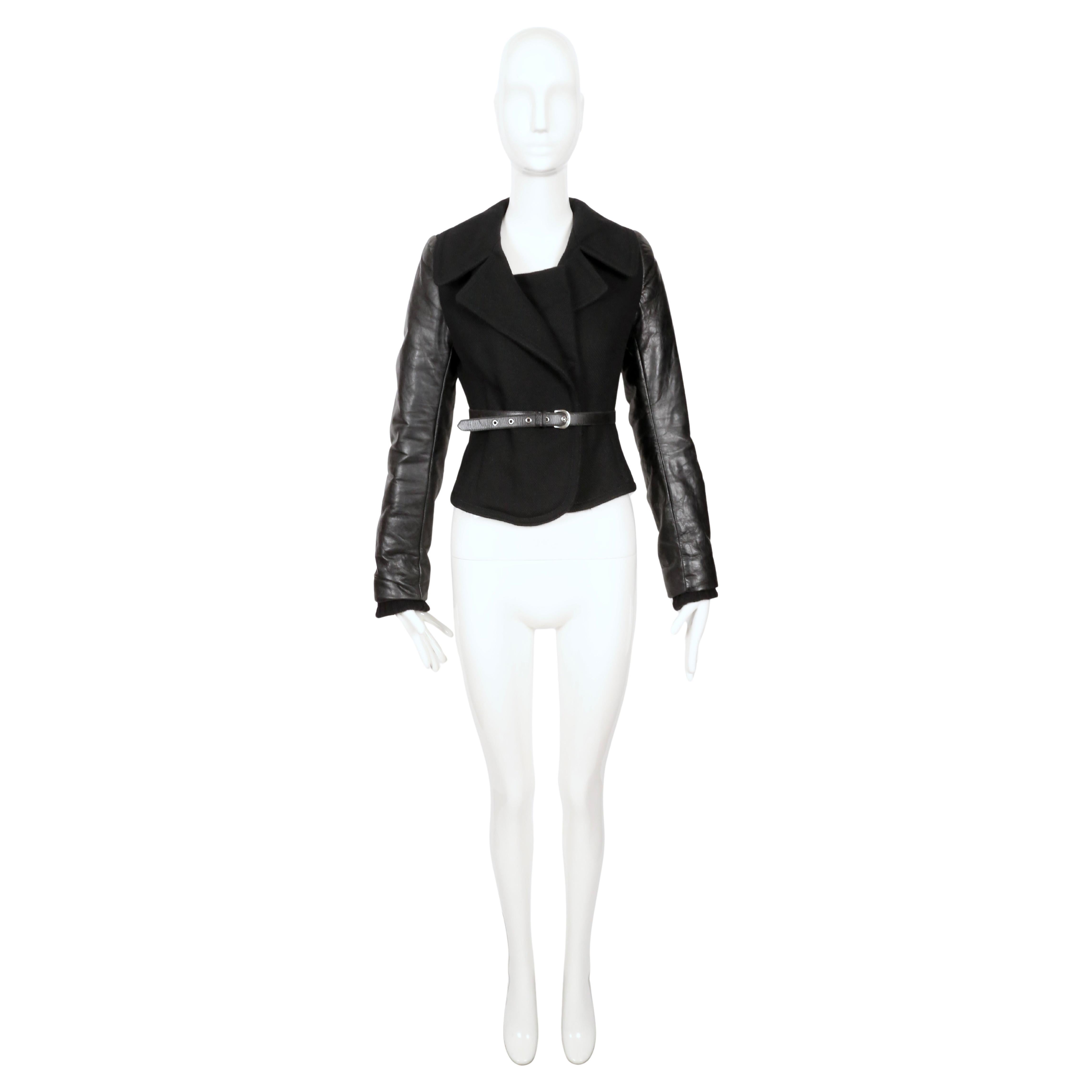 Rarísima chaqueta de lana negra con mangas y cinturón de piel de Balenciaga que data del otoño de 2002, exactamente como se vio en la pasarela. Talla 38 francesa, aunque ésta se ajusta mejor a una talla 36 francesa o US 2.  Medidas aproximadas: