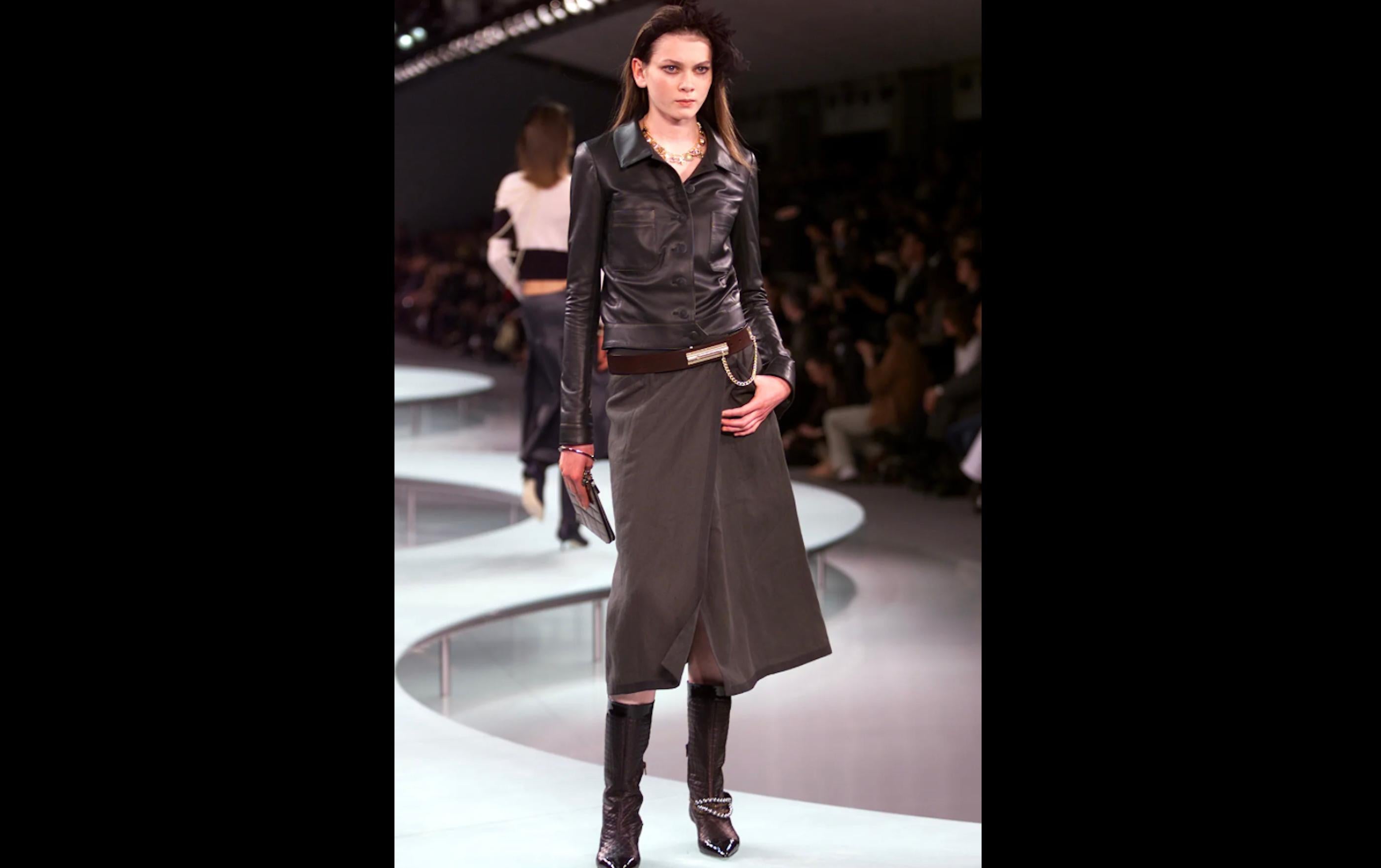The 2002 Chanel Runway Green Lambskin Leather Jacket is a stunning piece that epitomizes the luxurious craftsmanship and timeless elegance synonymous with the Chanel brand. Made from supple lambskin leather, this jacket offers a perfect blend of