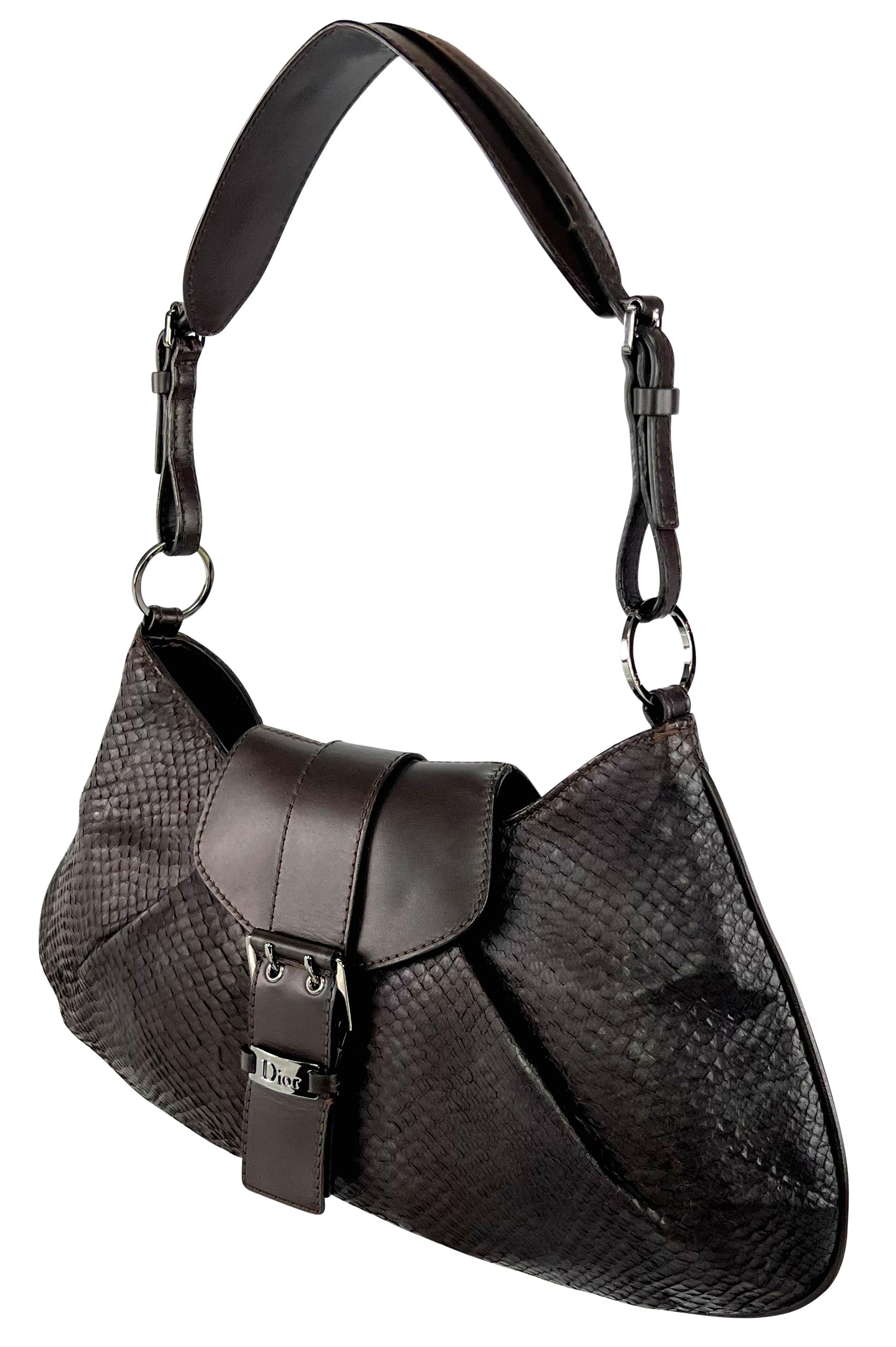 Designed by John Galliano in 2002, this sleek dark brown Christian Dior bag is crafted from python skin with leather accents. The shoulder bag has a flap design with a buckle closure, complemented by silver-tone metal details. It also features an
