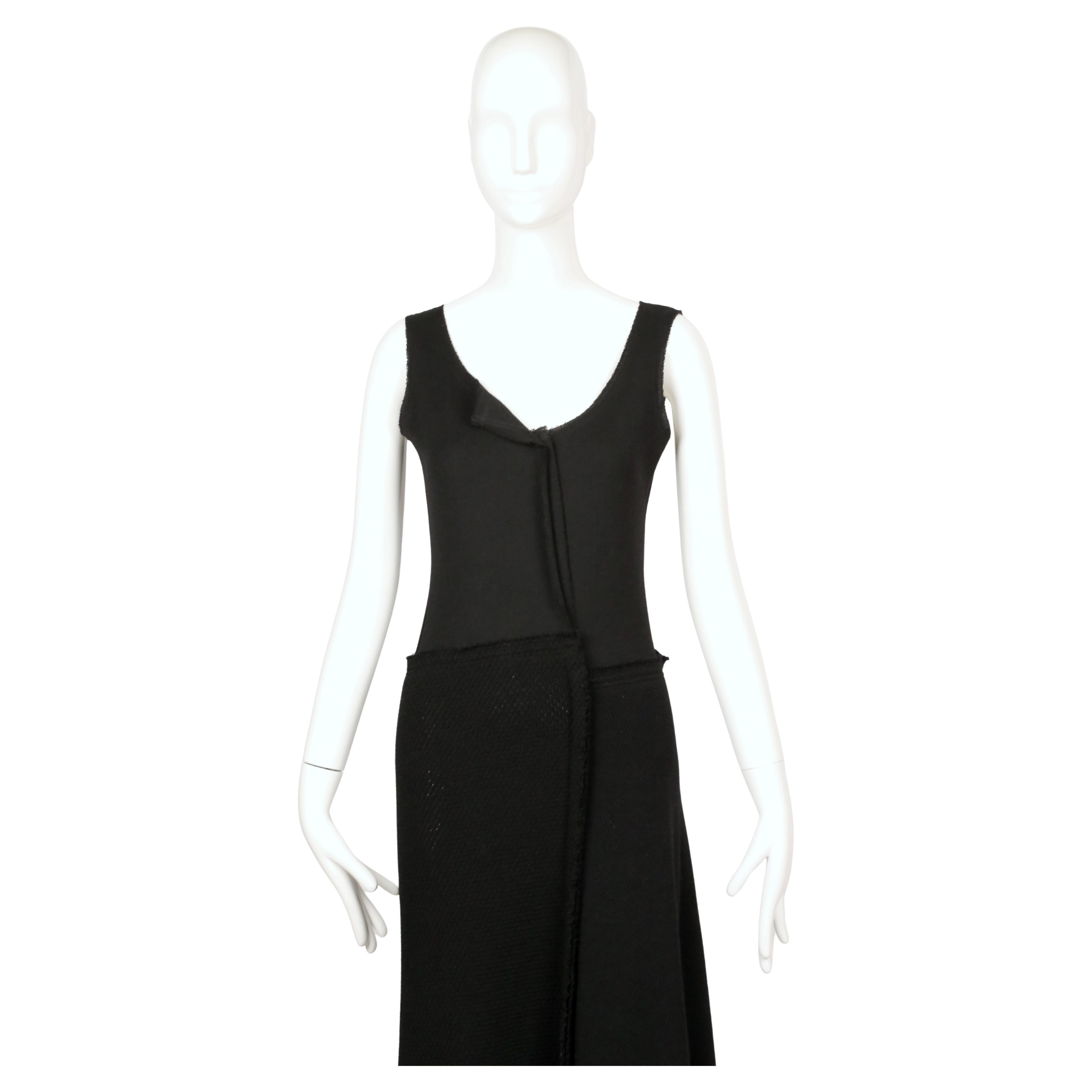 Robe avant-gardiste en maille de laine noire conçue par Rei Kawakubo pour la collection automne/hiver 2002 de Comme des Garçons. La pièce présente un aspect déconstruit et superposé, fréquemment utilisé dans les vêtements de Kawakubo de cette