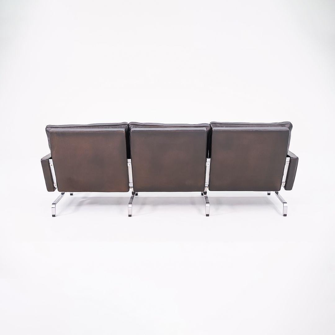 Il s'agit d'un canapé 3 places Poul Kjaerholm PK31, initialement conçu par Poul Kjaerholm pour Fritz Hansen en 1958. Cet exemplaire a été produit en 2002 au Danemark. Nous avons actuellement en stock deux canapés PK31 assortis en cuir noir, vendus à