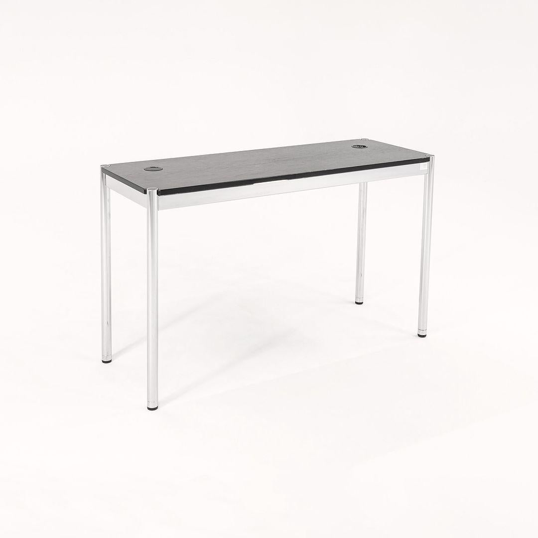 This is a USM Haller console / end table, originally designed by Fritz Haller. This particular example was produced by USM Haller in Switzerland circa 2002. The table is comprised of polished chrome framing and an ebonized wood top. 
 
 The table