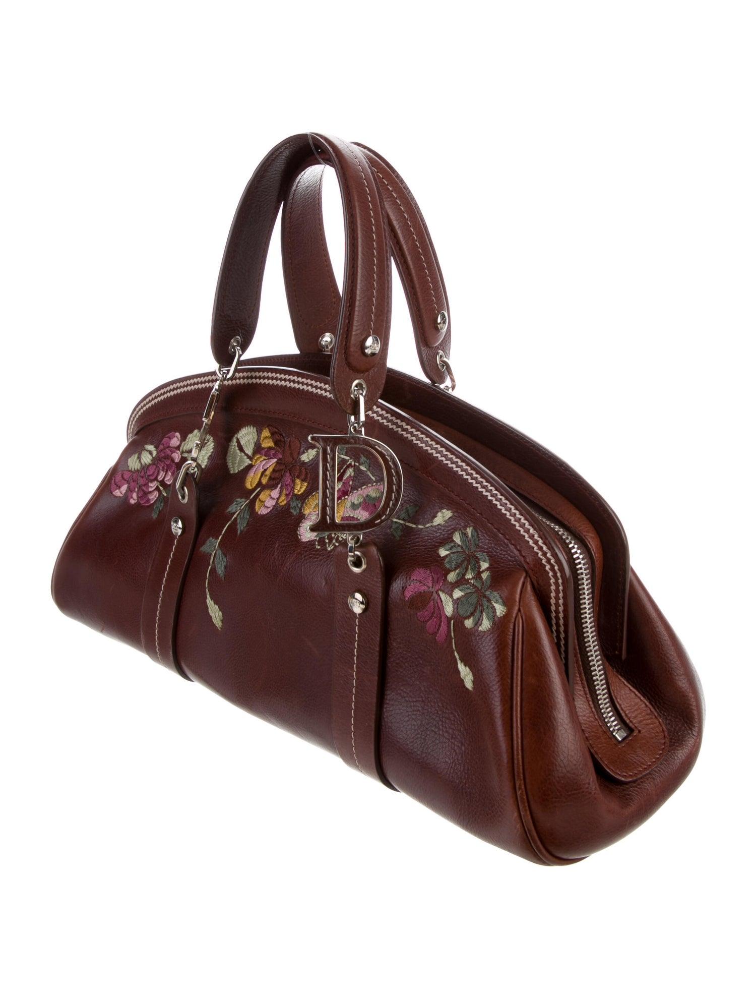 Christian Dior Top Handle Bag
2002 Collection by John Galliano

Details:
Brown Leather
Floral Embroidery
Silver-Tone Hardware
Flat Handles
Logo Jacquard Lining & Single Interior Pocket
Zip Closure at Top
Protective Feet at Base

Condition: Excellent
