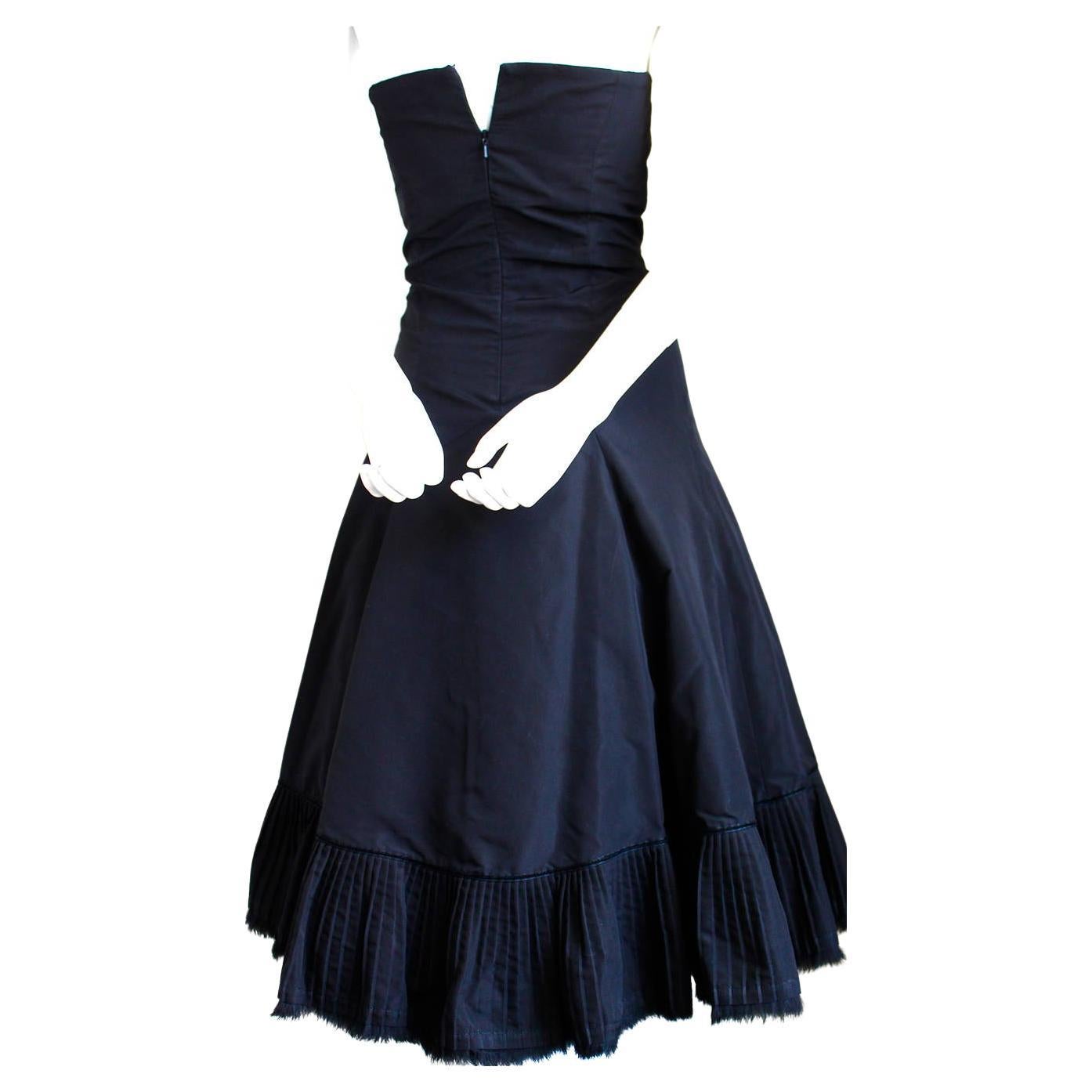 Jet-black taffeta strapless dress with pleated hemline trimmed in fur from Alexander McQueen dating to fall of 2003. Best fits a slim size 2. Approximate measurements: bust 31-32