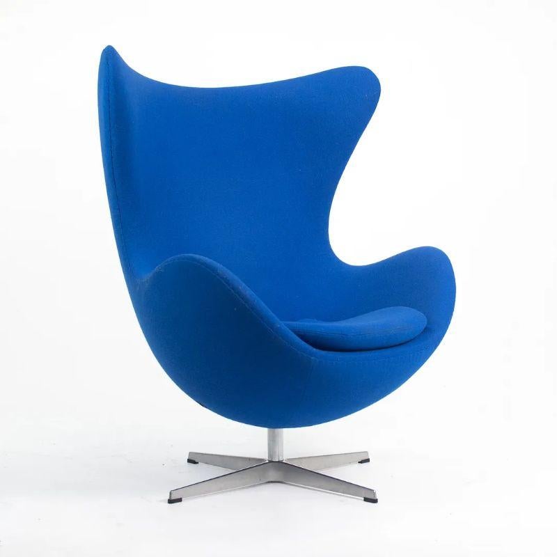 This is a single Egg Chair designed by Arne Jacobsen and produced by Fritz Hansen in Denmark in 2003. The price listed is for one chair, though multiples are available. Each chair is upholstered in a blue hopsack-like upholstery, likely Tonus by