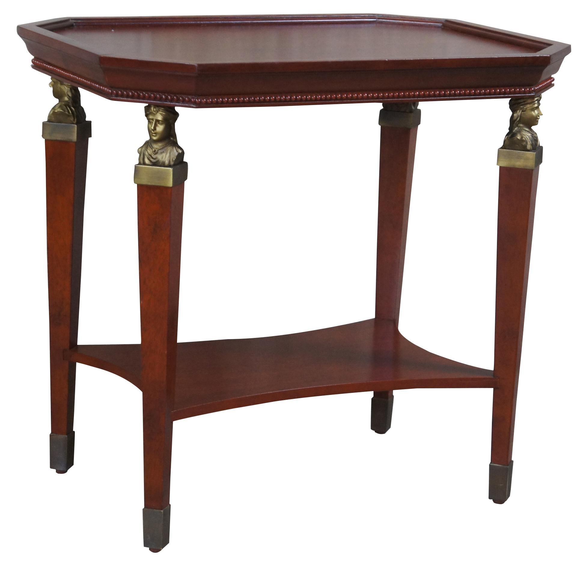 Bombay Company Egyptian revival end table. Made from cherry with an octagon shape inset top and beeded trim. The table is supported by square tapered legs topped with glowing figural brass caryatid mounts. Legs terminate into brass capped feet.
 