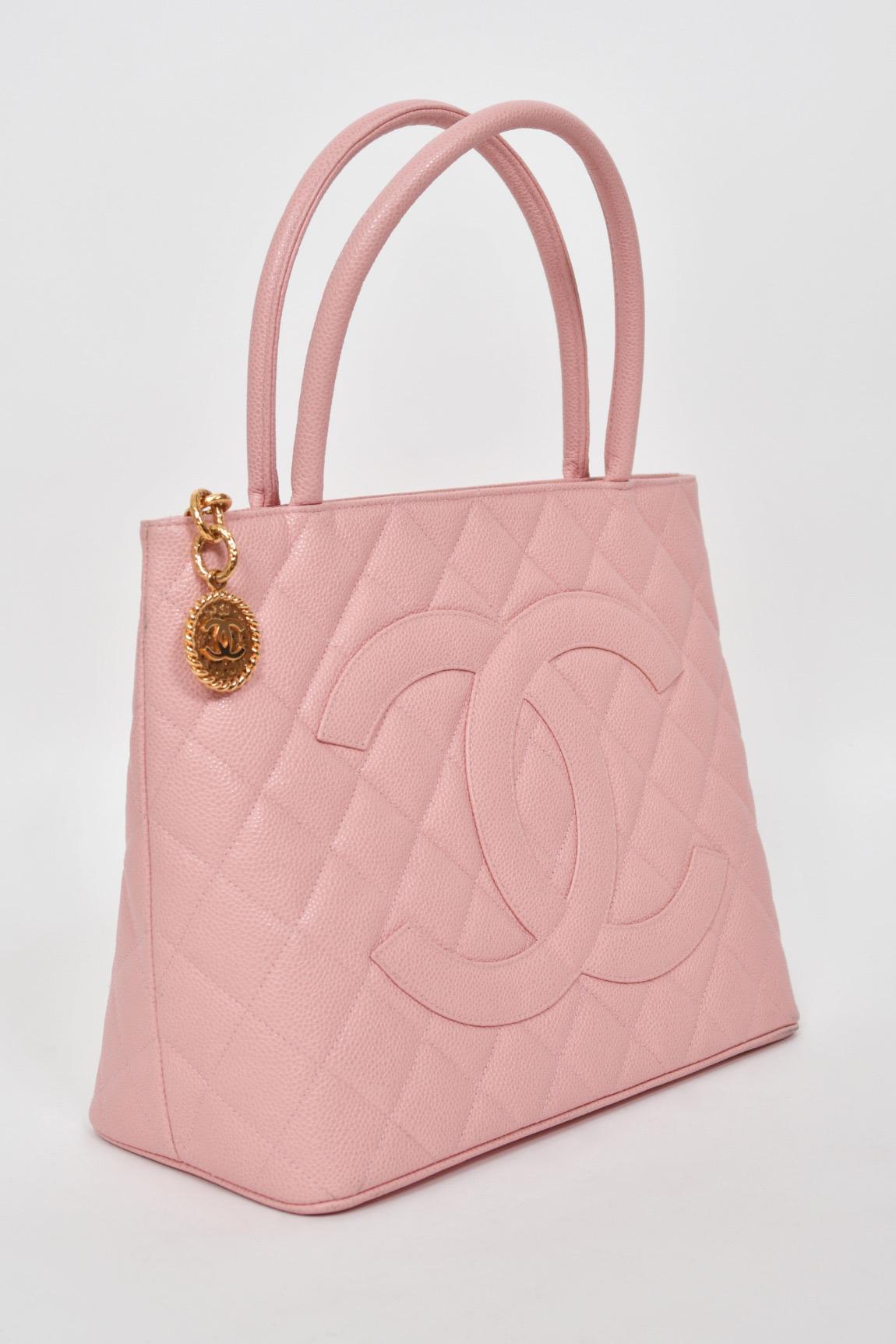 Chanel is known to be one of the most luxurious and decadent fashion houses in the world. This archival 2003 by Karl Lagerfeld pale baby-pink medallion tote purse is a perfect example of why this couture brand has stood the test of time. The