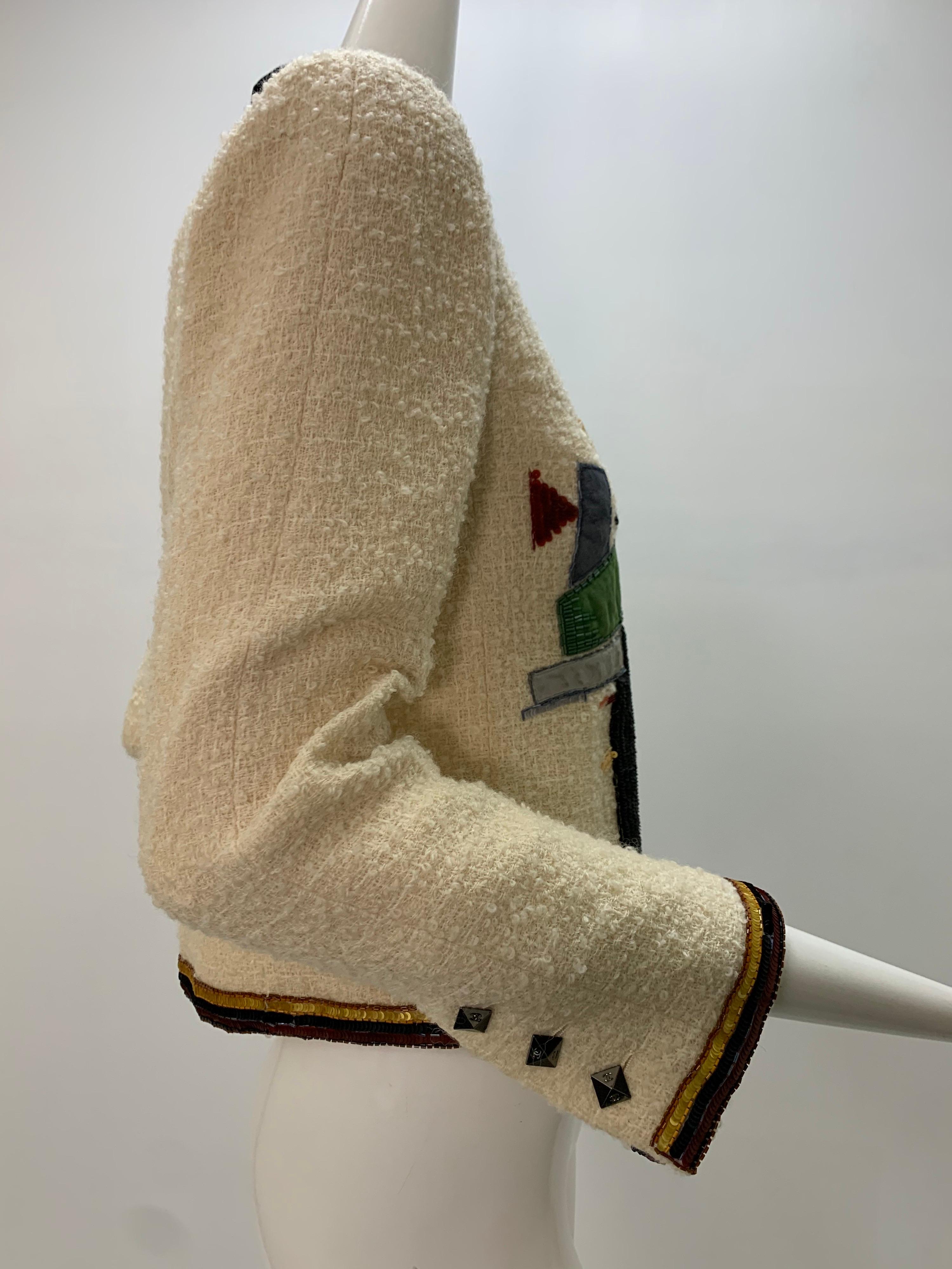 2003 Chanel cream wool boucle cropped jacket with zip front and abstract patchwork beaded and sequined design on both sides of front. Banded black velvet collar, fully lined with trademark gold chain sewn into hem. Size 42
