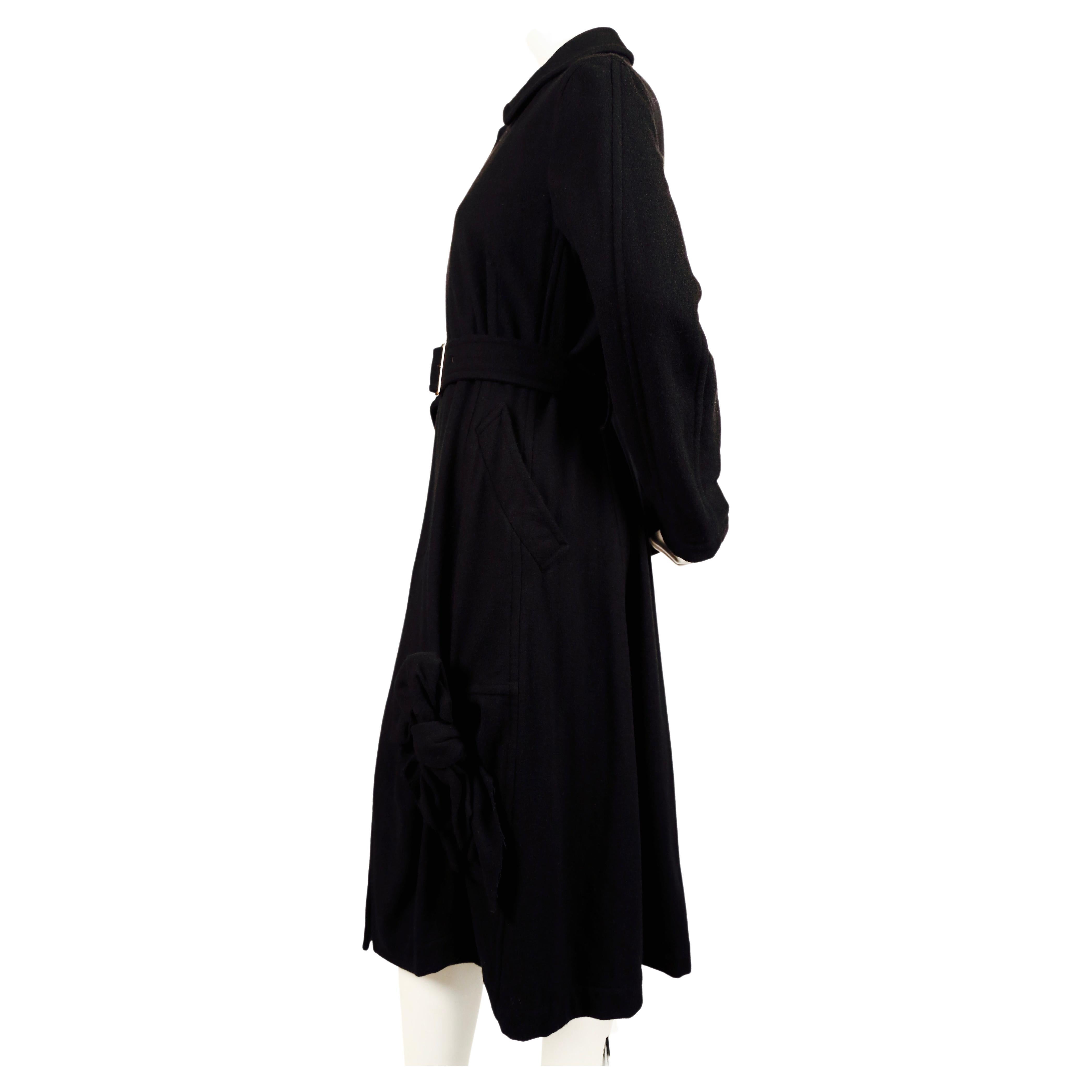 Jet black wool coat with unique 'knot' detail from Comme Des Garcons dating to 2003. Size is unlabeled however coat best fits a small or medium. Approximate measurements: shoulder 16