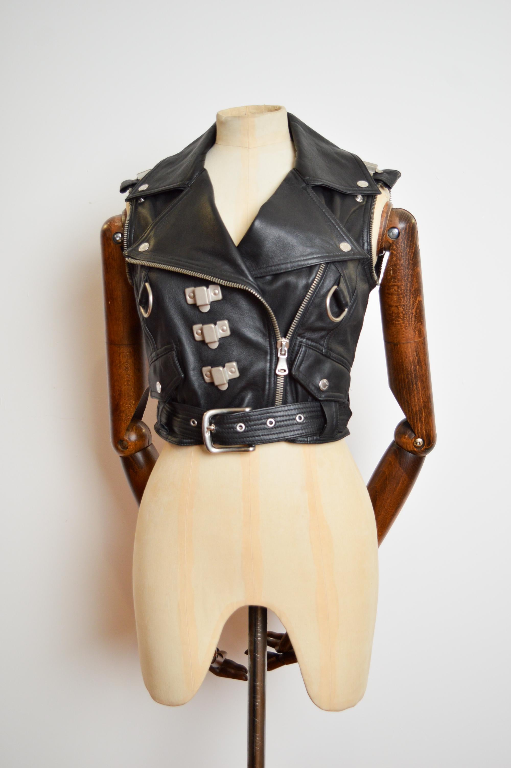 Vintage 2003 DOLCE & GABBANA Gilet da motociclista in pelle nera con scritta 'Eagle, Biker flame' sulla schiena sotto lo slogan 'D&G Pin Up'.

L'indumento presenta cerniere e hardware argentati sul davanti, una cintura in vita, un retro con stampa