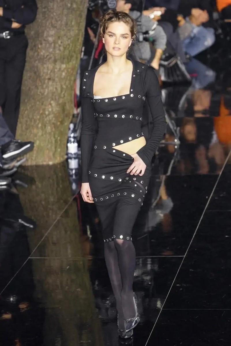 Unleash your inner fashion icon with the 2003 Dolce & Gabbana F/W runway black knit snap-up convertible dress.  This captivating piece effortlessly blends sophistication and playfulness.  Its unique snap-up design allows for customizable styling,