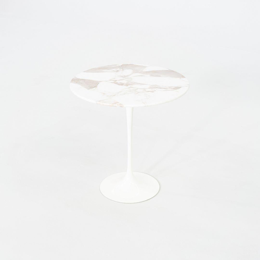 This is a Tulip Side Table, initially designed by Eero Saarinen for Knoll in 1956. This particular example was produced by Knoll in the USA and dates back to the year 2003. The base is formed of molded cast iron and the tabletop is Calacatta Gold