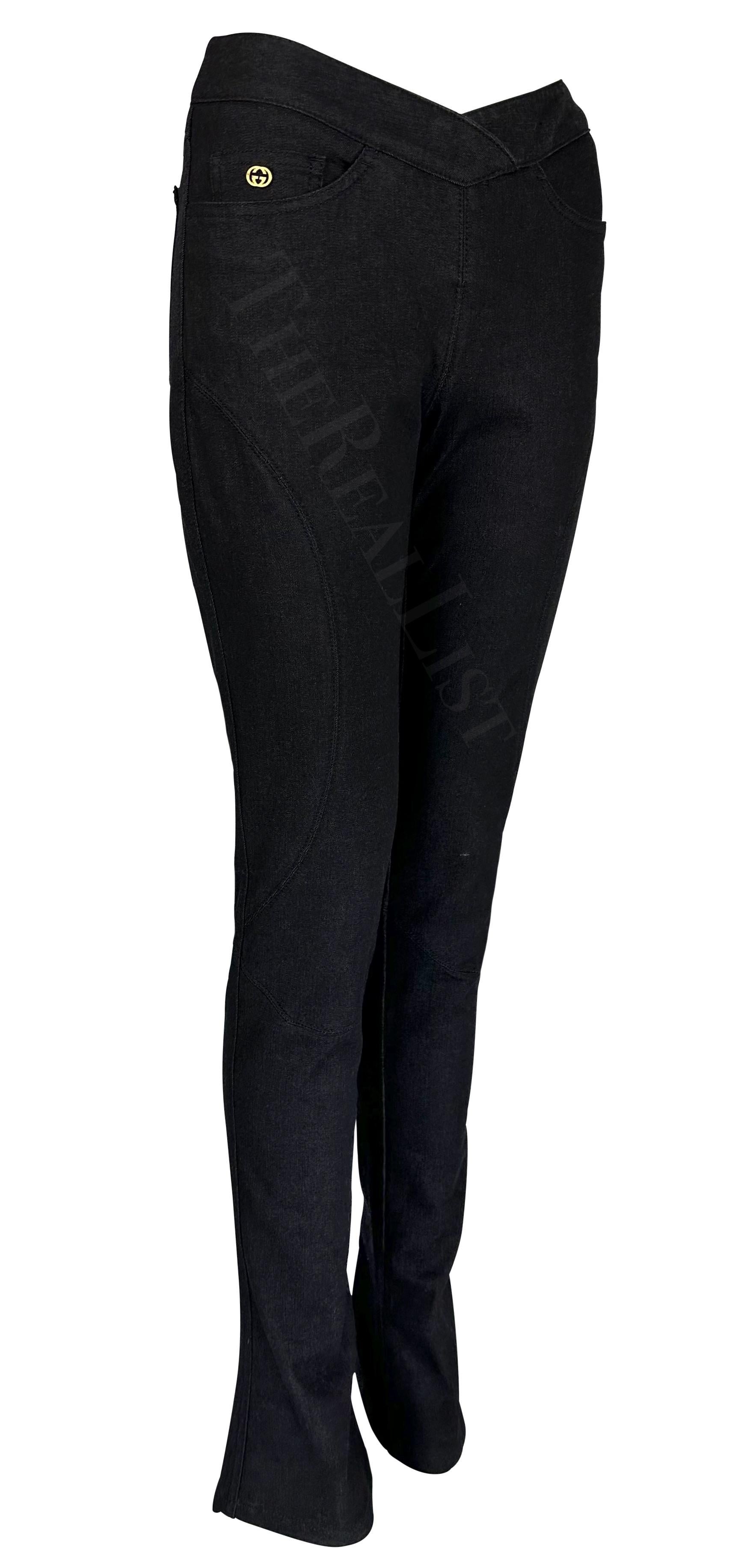 Presenting a pair of black denim Gucci jeans, designed by Tom Ford. From 2003, these fitted pants feature a flare at the hem, an angular cut waist, and a gold-tone 'GG' accent at one pocket.

Approximate measurements:
Size - 38IT
Waist: 28