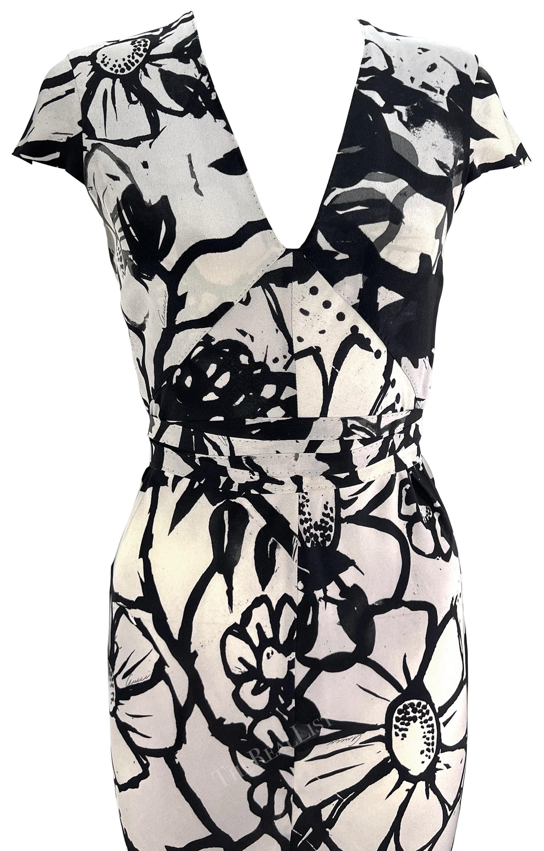 Presenting a chic grey floral Gucci dress, designed by Tom Ford. From 2003, this dress is covered in a bold abstract floral print atop a grey background. This fabulous knee-length dress features petite petal sleeves, a v-neckline, and a tie belt