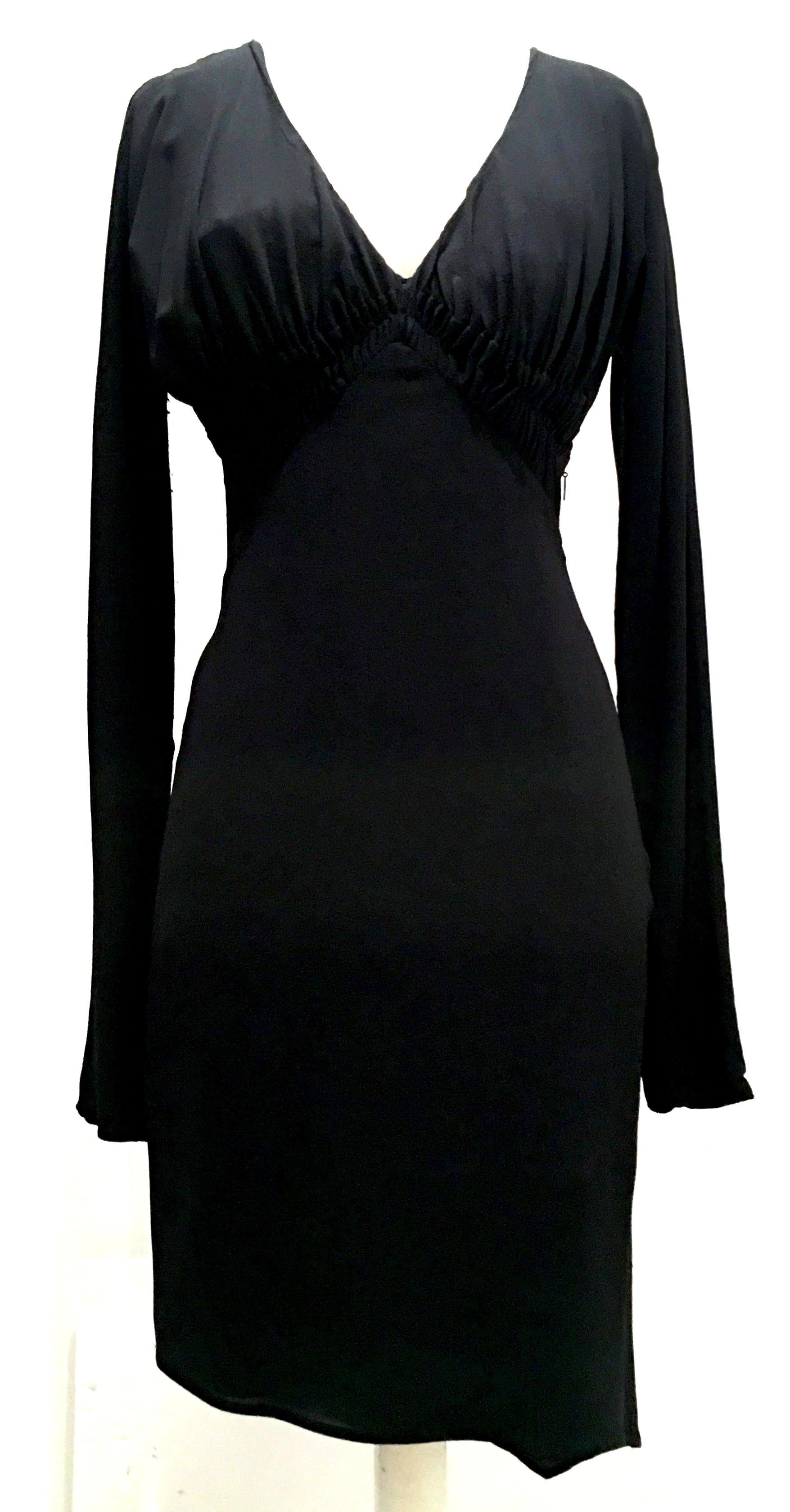2003 Italian silk long sleeve deep plunge form fitting little black dress by, Tom Ford For Gucci-size 42. This form fitting fully lined dress featured a deep plunge neck with empire rouche detail, and asymmetrical hem. The black Gucci logo zipper is