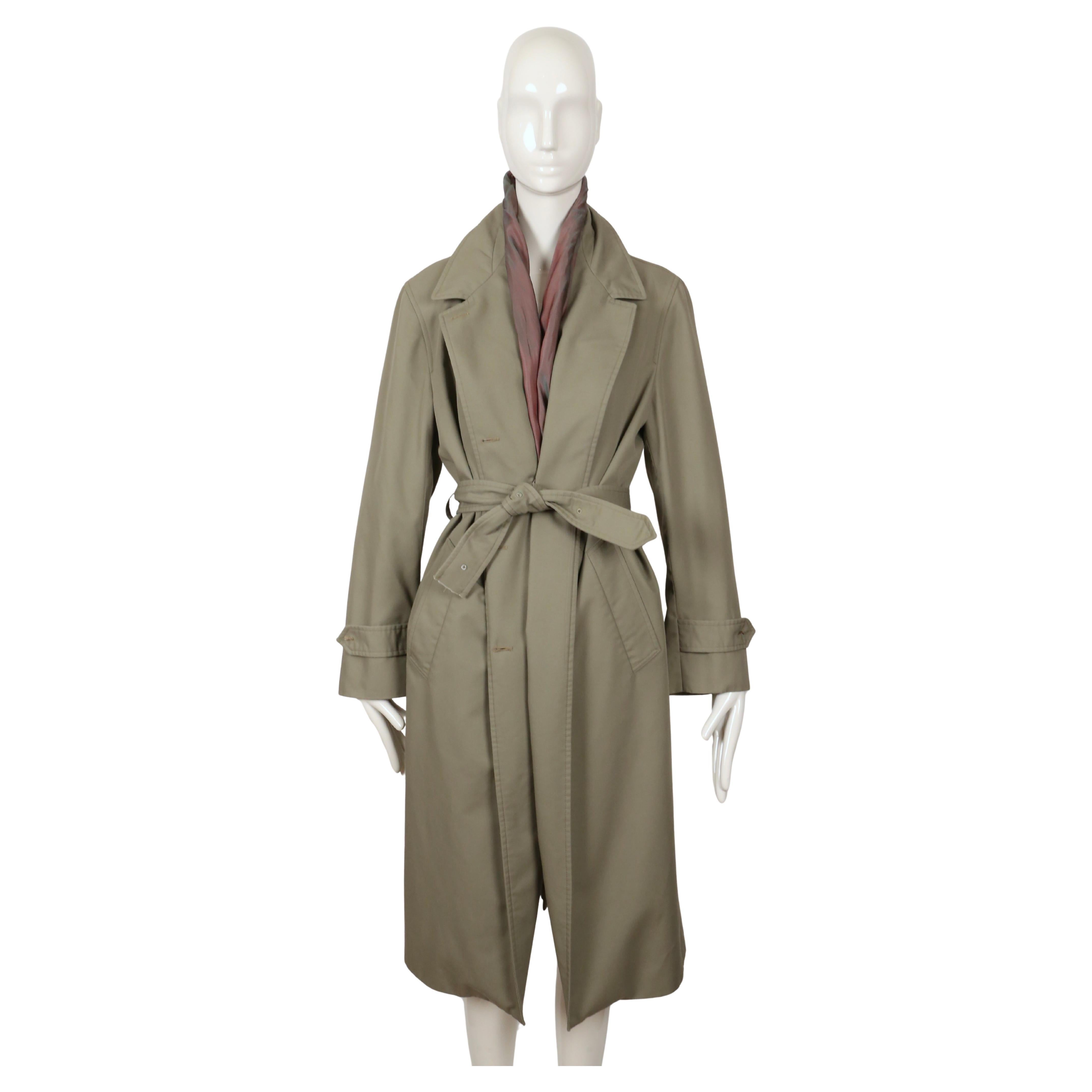 Rarissimo trench decostruito con fodera iridescente a vista,  Cintura in vita 'tagliata' e bottoni 'mancanti' con fili a vista disegnati da Martin Margiela nella primavera del 2003, esattamente come visti in passerella. Inoltre, è presente nel