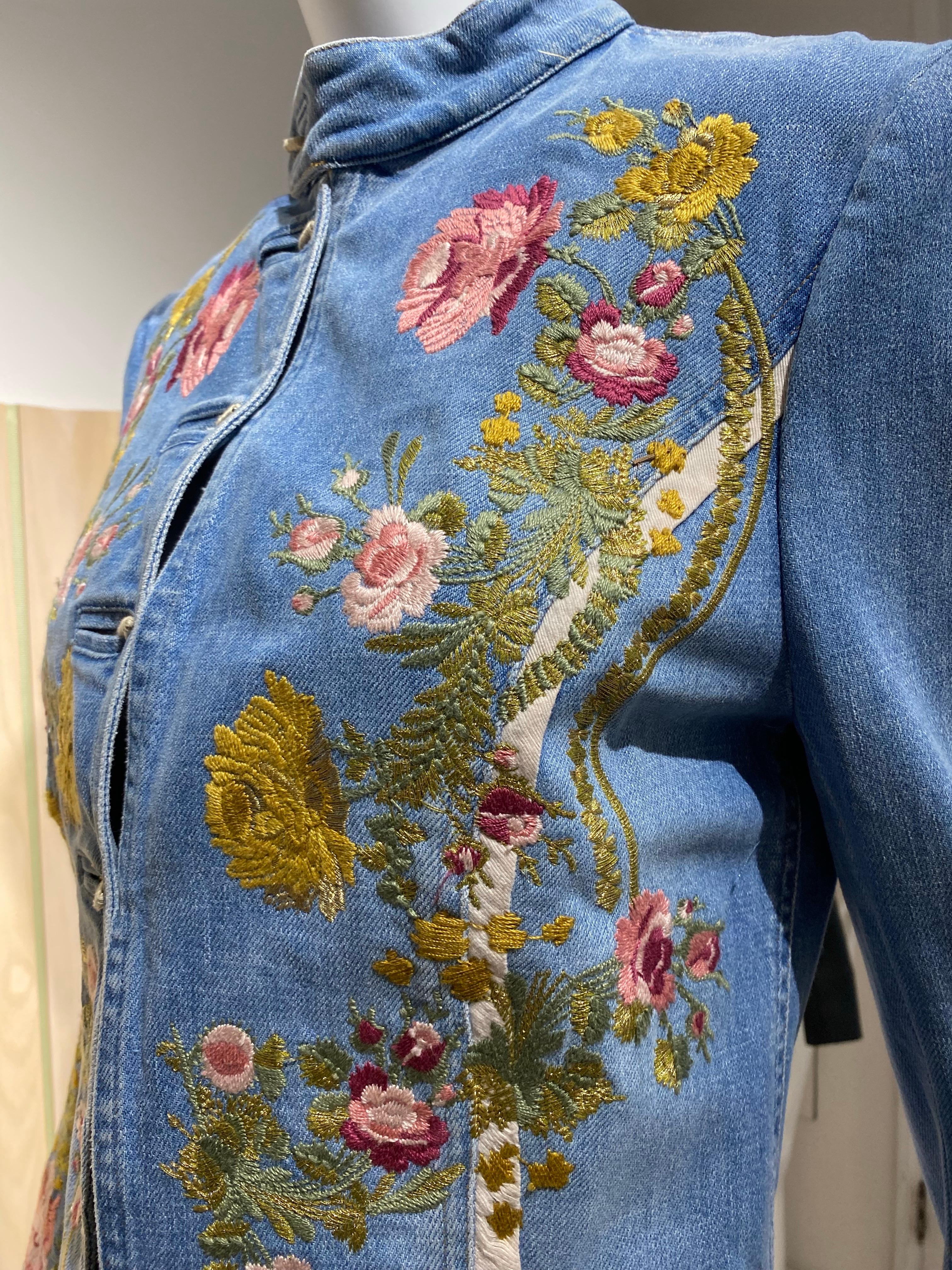 2003 Roberto Cavalli Fitted  denim jacket embroidered in floral motif.
color : pink, yellow , green and white
long sleeve, buttons, nehru collar, and faux pockets
Size Small fit US 2/4