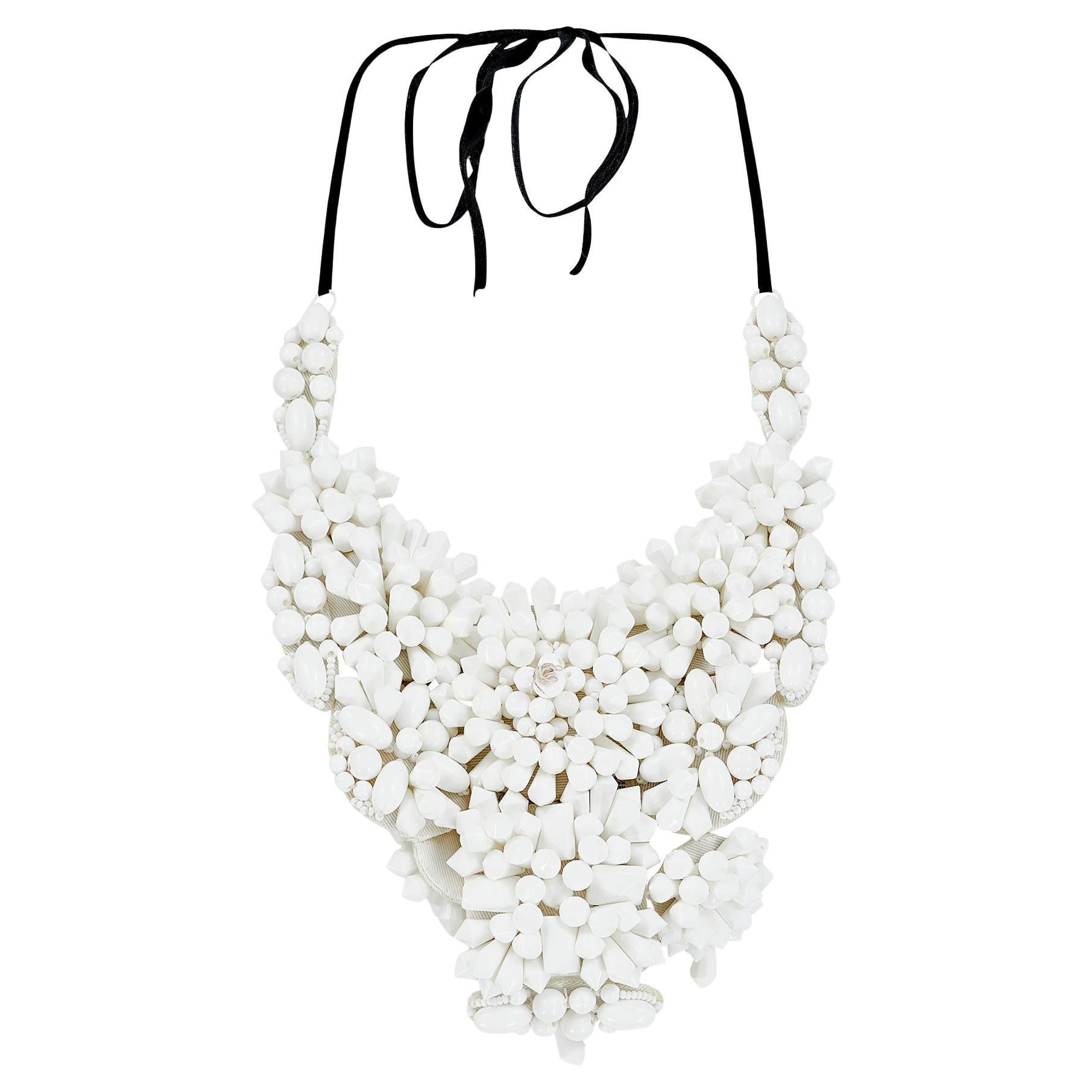 This runway documented necklace adorned the necks of multiple models walking in Prada’s Spring 2003 collection. Appearing in both black (look 22/40) and white (as look 10/44), this heavily beaded piece adds a futuristic glamour to the minimalist