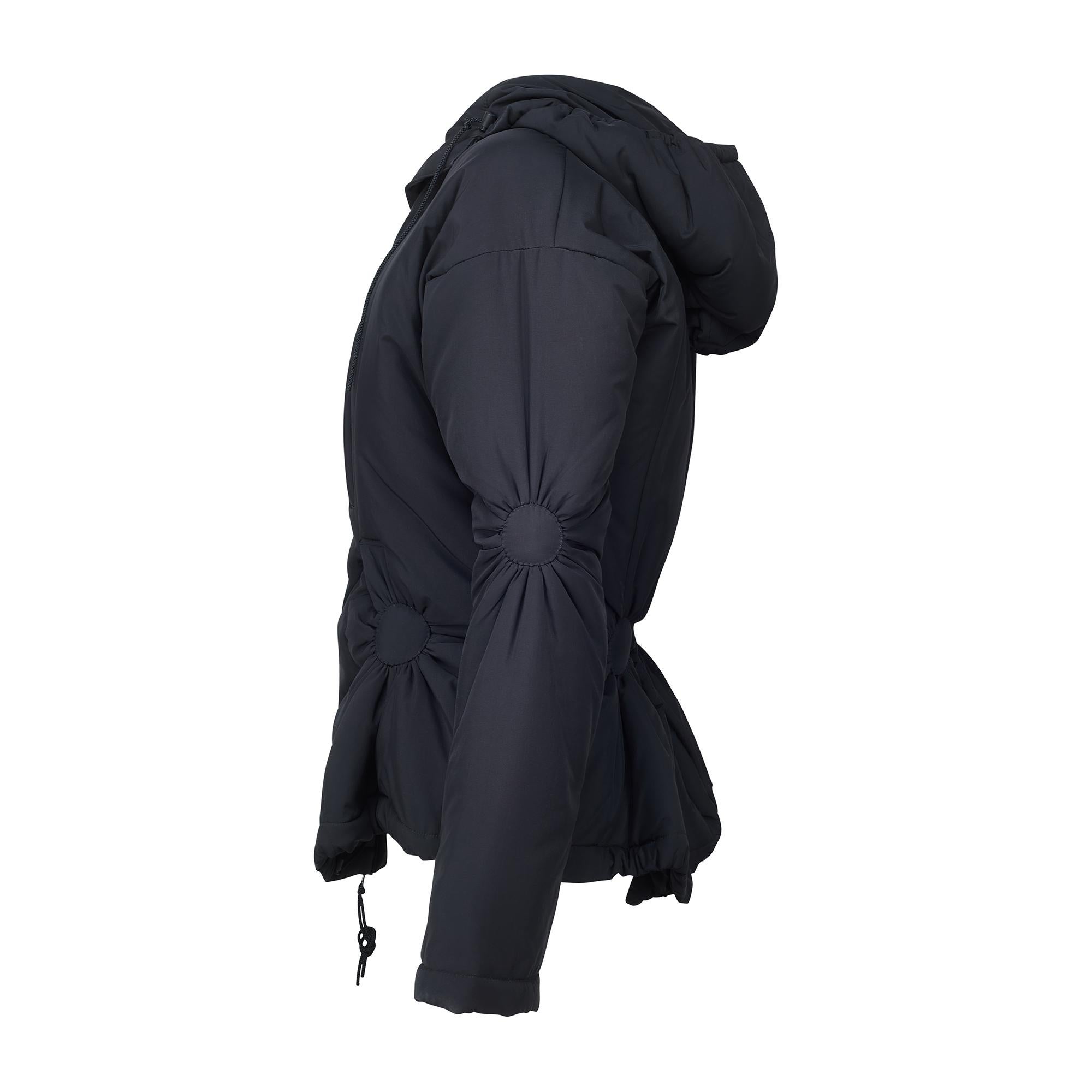 Diese von Naoki Takizawa für die Issey Miyake Herbst/Winter 2003 Kollektion entworfene Jacke wurde in Japan hergestellt. Es ist aus glattem, schwarzem Polyester mit einem flauschigen Cupro-Futter geschneidert und mit den avantgardistischen Formen