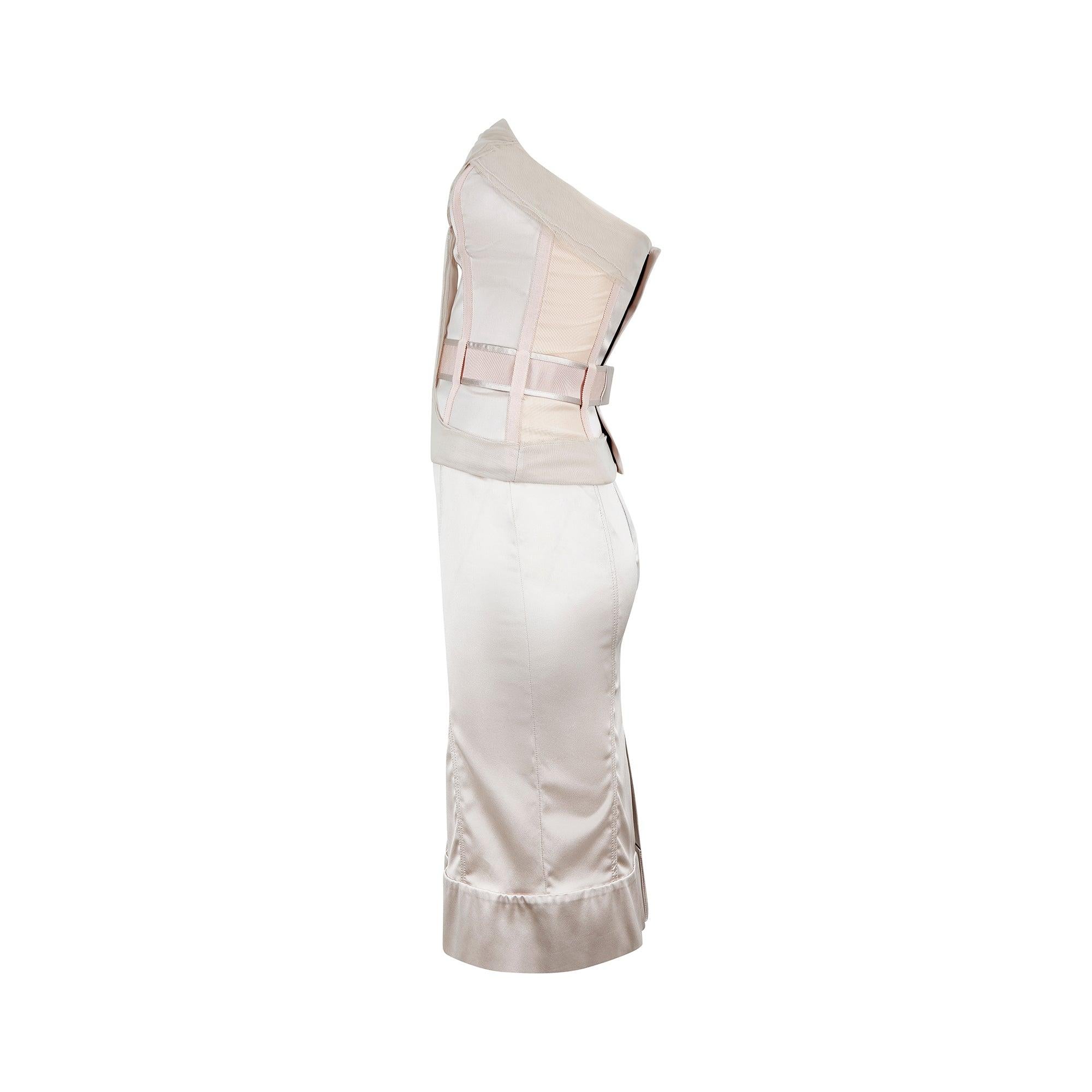 Seen on Kylie Minogue on the cover of the December 2003 issue of British Vogue, this collectable pale 'oyster' pink satin two-piece is by Stella McCartney. The skirt is tight-fitting with a panelled construction and falls to knee length with a thick
