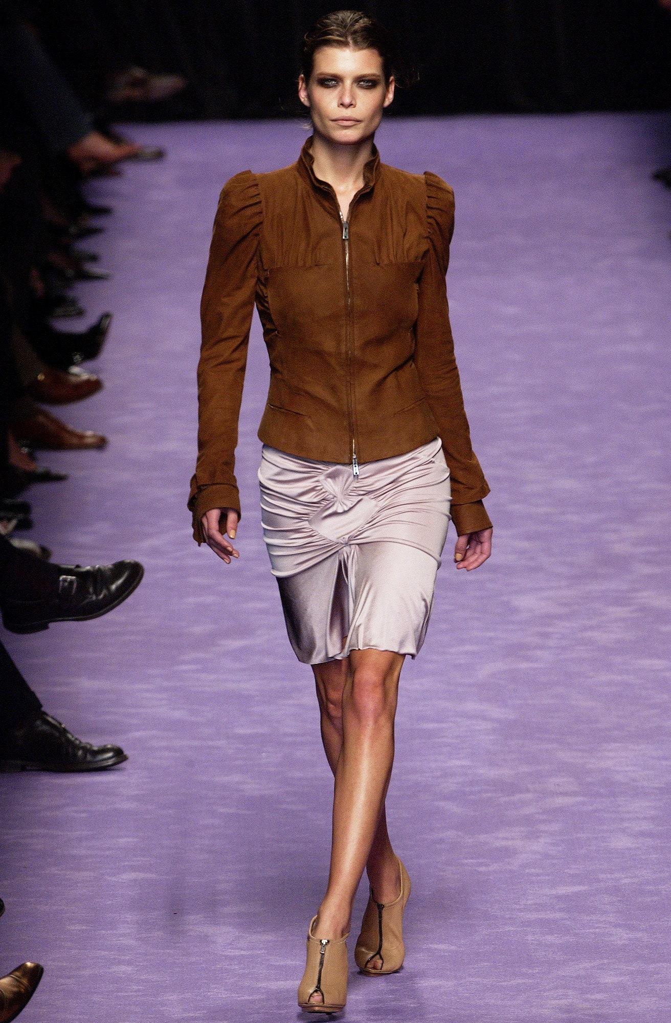 Excellent Tom Ford era brown suede bomber jacket from the 2003 S/S RTW collection. Seen on the runway with a blush purple satin skirt, the jacket features ruched accents at the shoulder and along the bust. A unique feature on the bust reveals the