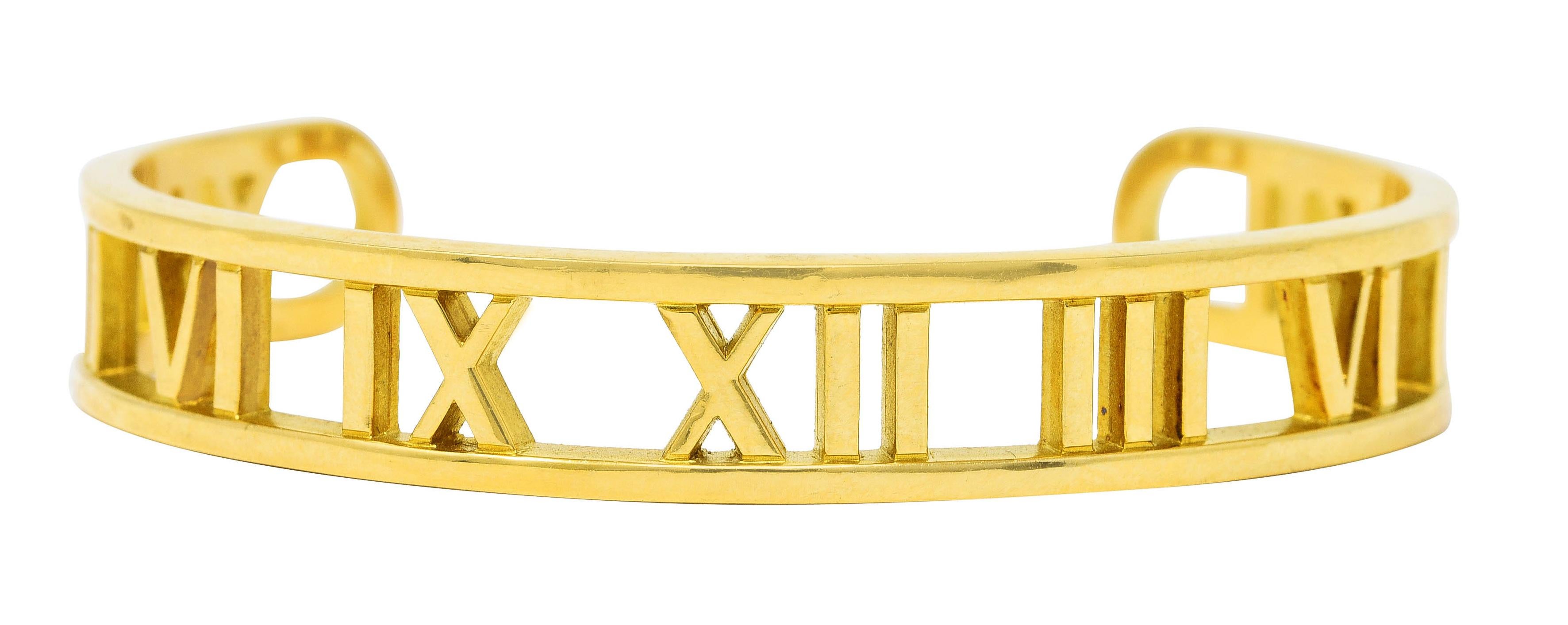 Cuff bracelet is designed as a contoured channel centering pierced roman numerals

Featuring a high polished gold finish

Completed by rounded terminals

Stamped 750 for 18 karat gold

Fully signed Tiffany & Co. Italy

Circa: Dated 2003 from the