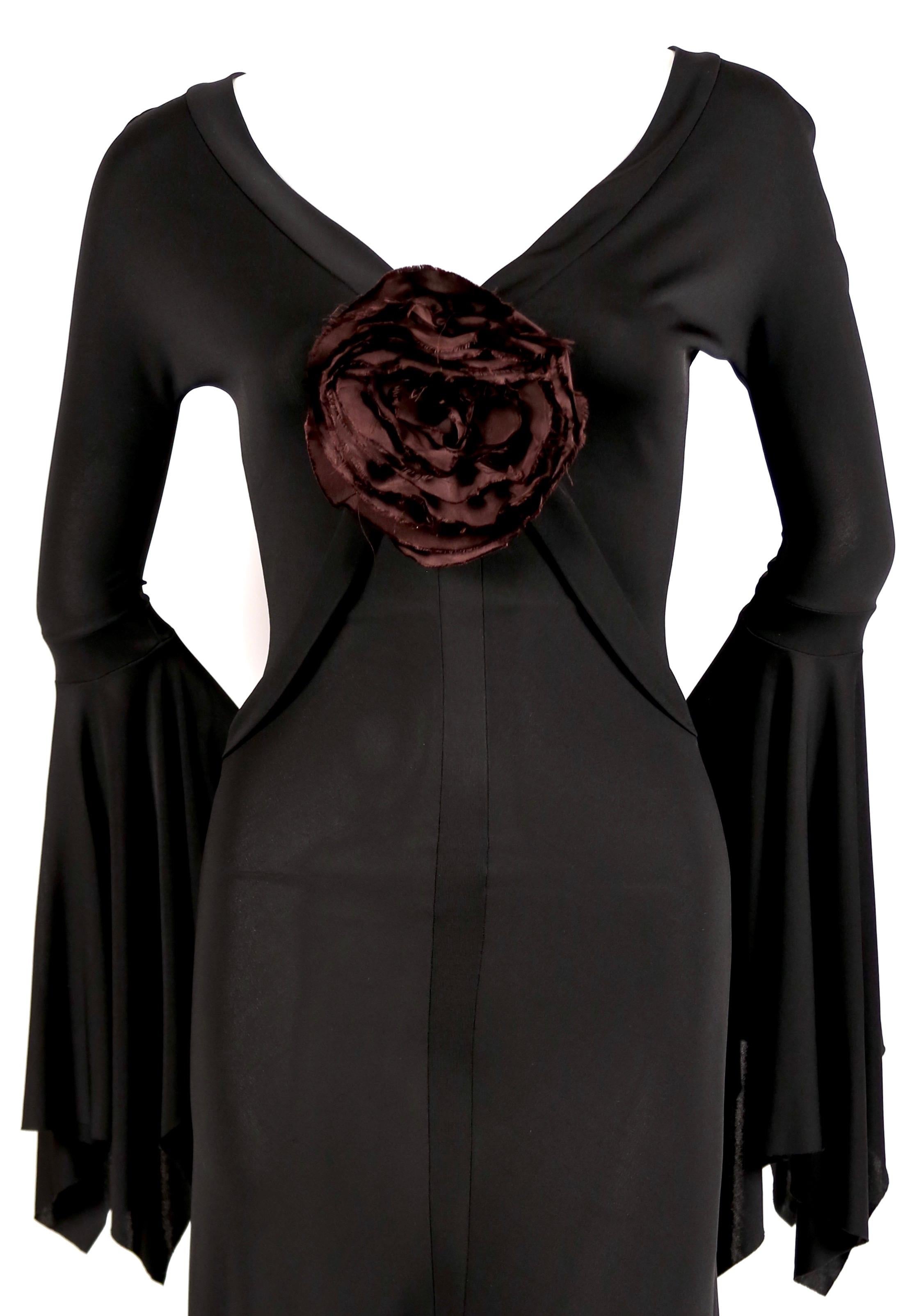 Very rare, jet-black jersey dress with bell sleeves and dramatic oversized purple flower detail designed by Tom Ford for Yves Saint Laurent exactly as seen on the spring 2003 runway. Size S which best fits a XS or S. Approximate measurements: bust