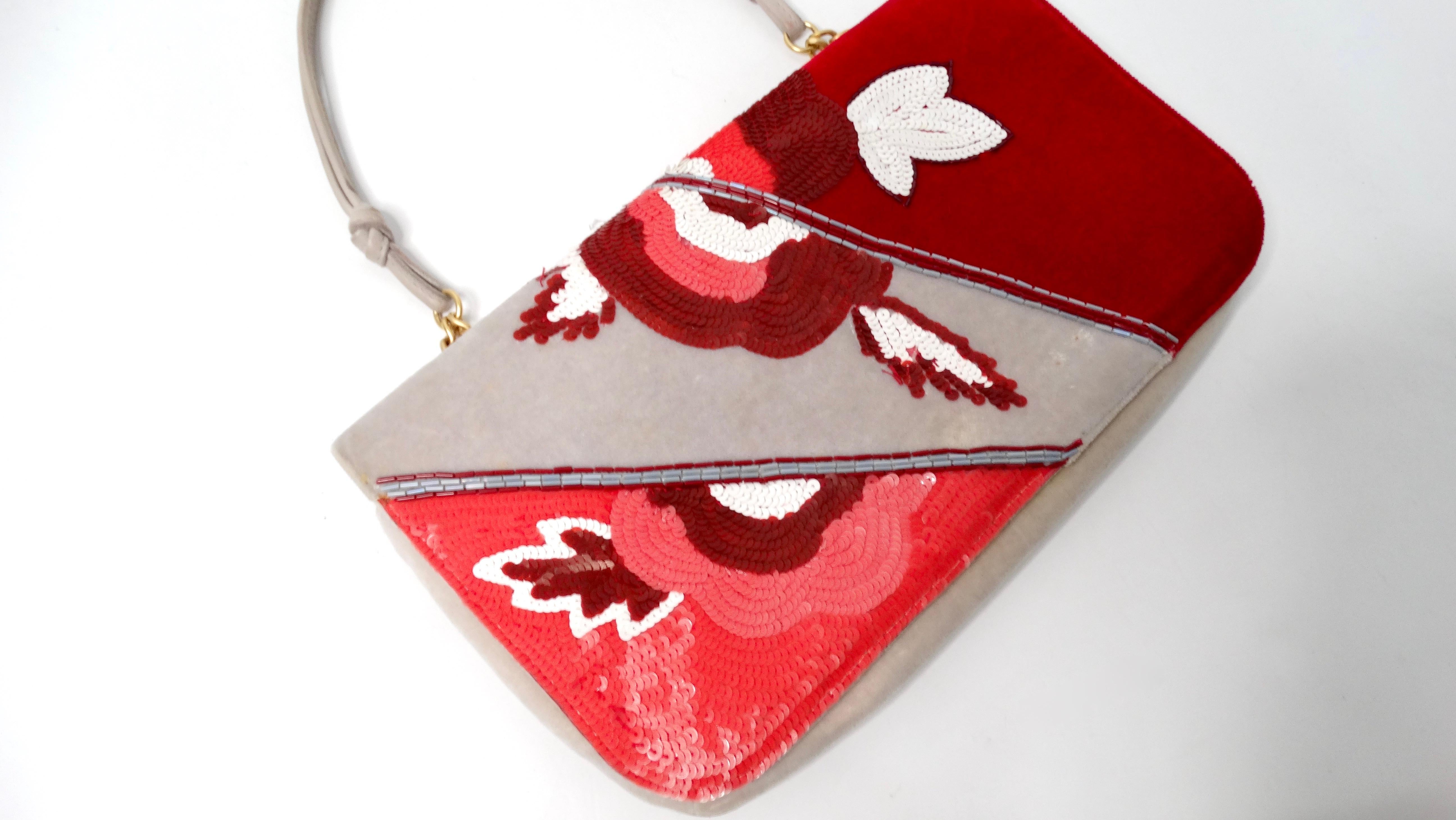 La pochette en velours et paillettes à imprimé floral de Chanel 2004 est une incarnation étonnante de la mode du début des années 2000 (an 2000). Fabriquée en velours luxueux, cette pochette unique présente un imprimé floral rouge, rose et gris