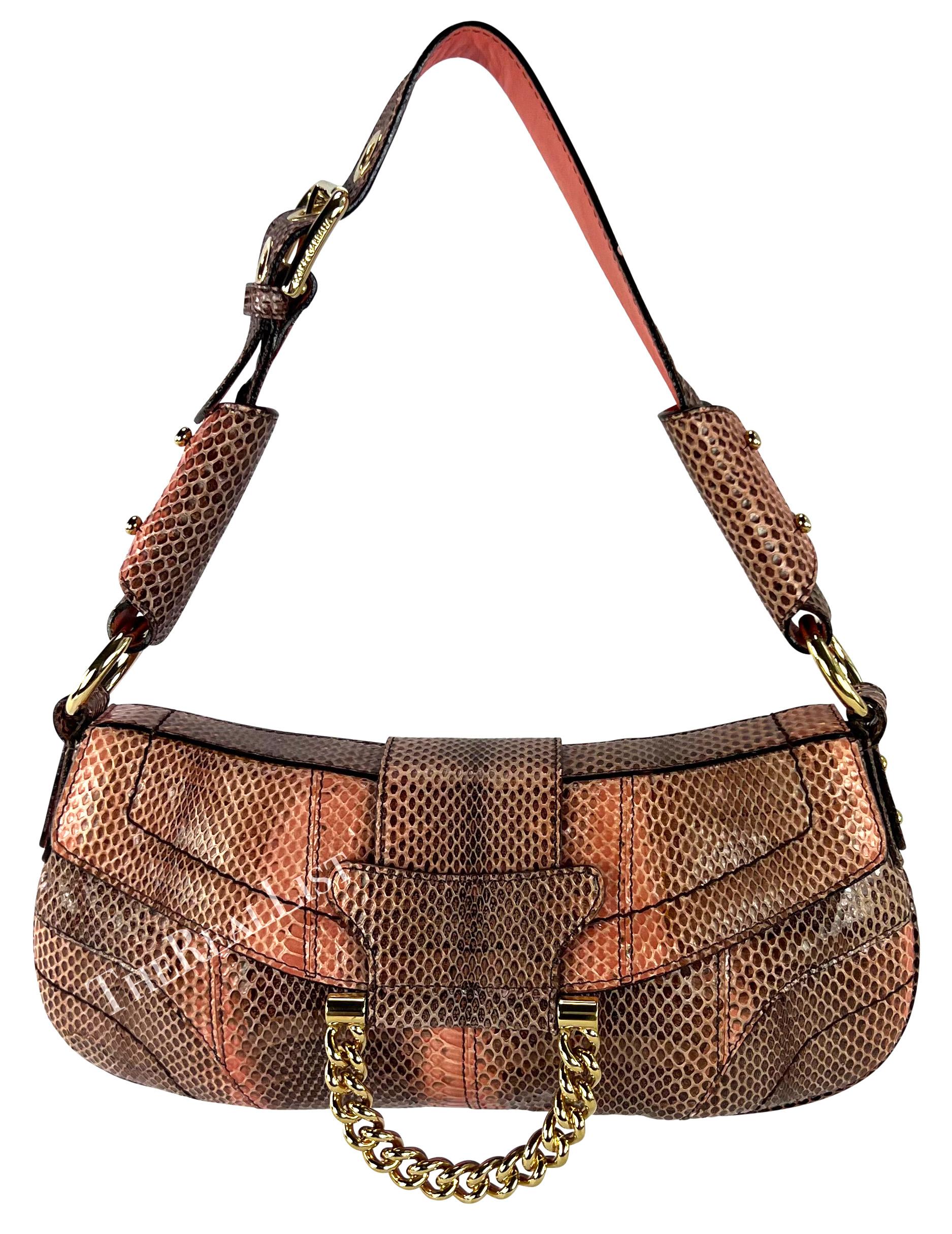 From 2004, this fabulous salmon pink python-skin Dolce & Gabbana shoulder bag has been constructed entirely of light pink python skin. This flap bag features gold-tone hardware with a gold-tone chain accent at the front and an adjustable buckle