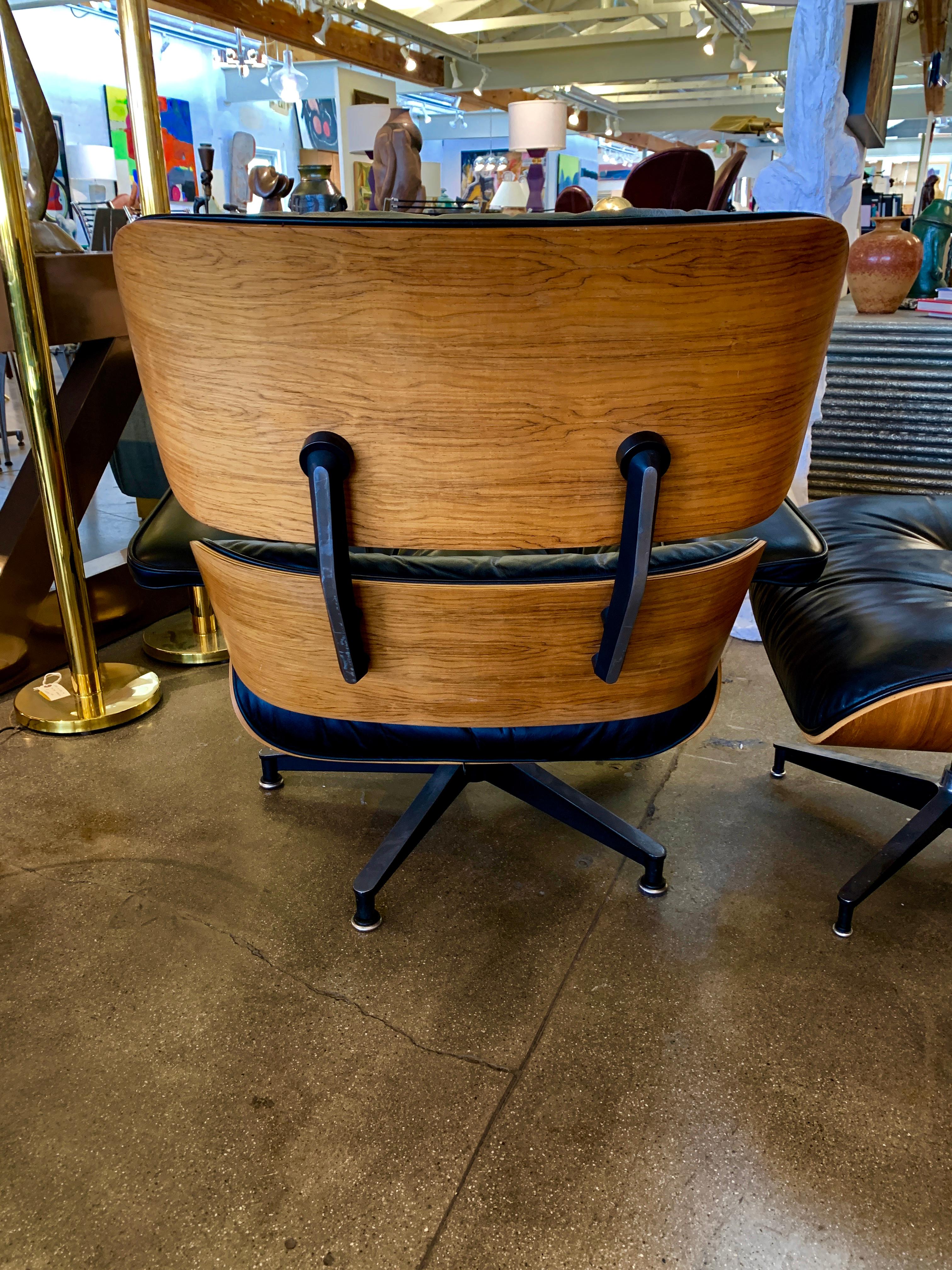 A 670 and 671 Herman Miller Eames lounge chair and ottoman produced in 2004. Both are tagged Herman Miller. Pretty creased patina to the leather. The wood shells are walnut. The Lounge has a production date tag of 03/23/2004. There are two spots on