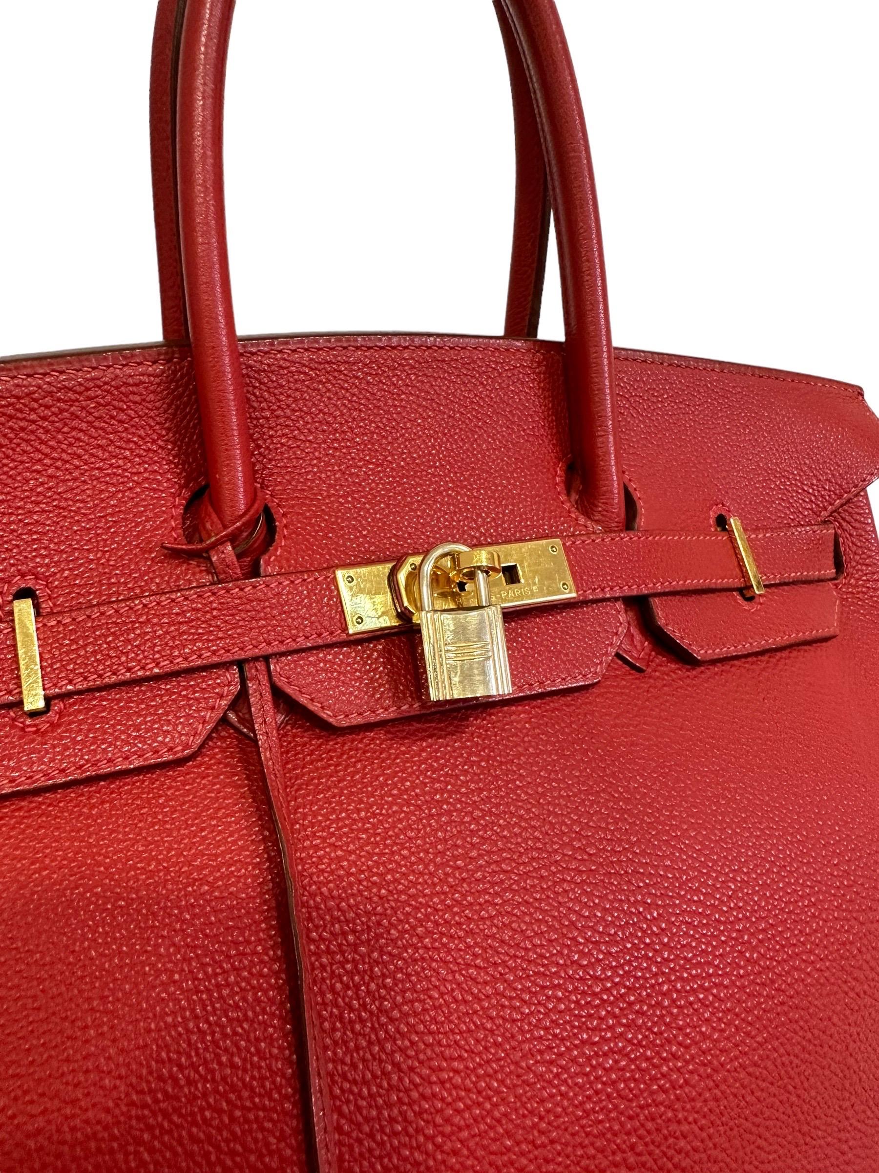 Hermès handbag, Birkin model, size 35, made in Geranium red Fjord leather with gold hardware. Equipped with the classic flap with interlocking closure with horizontal band. Equipped with padlock with clochette and keys. Double rigid hand handle and