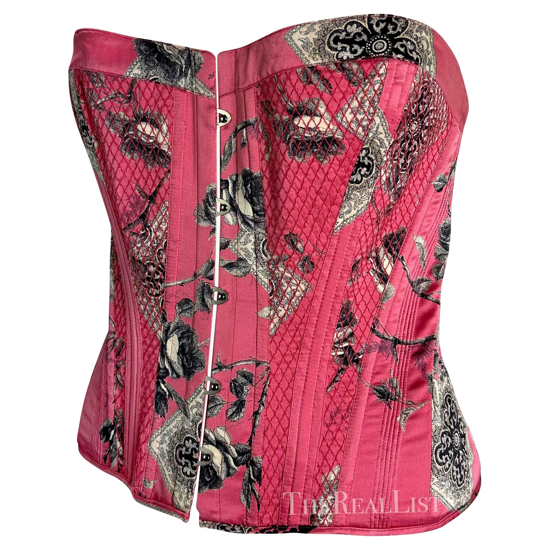 Presenting a bright pink floral Roberto Cavalli corset. From 2004, this fabulous corset features a steel hook eye closure at the front and a lace-up closure at the back. This sexy top is made complete with curved boning and a quilted