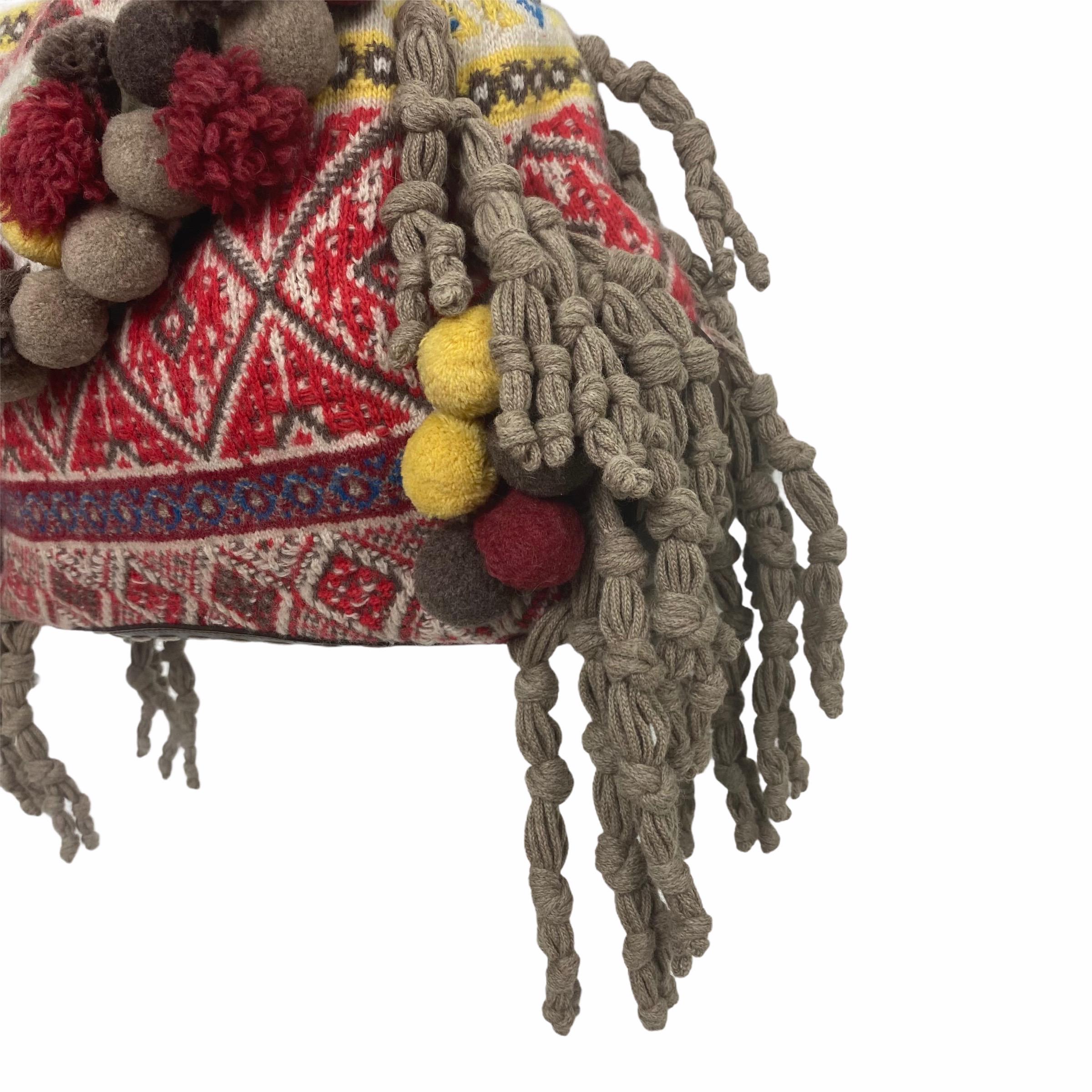 Highly collectible Alexander McQueen handbag

2005 Fall/Winter collection

Made of multi-colored knit and finished with pompoms and tassel trim, this bag will definitely bring the attention. Inside it is lined in suede and has a zip pocket. 