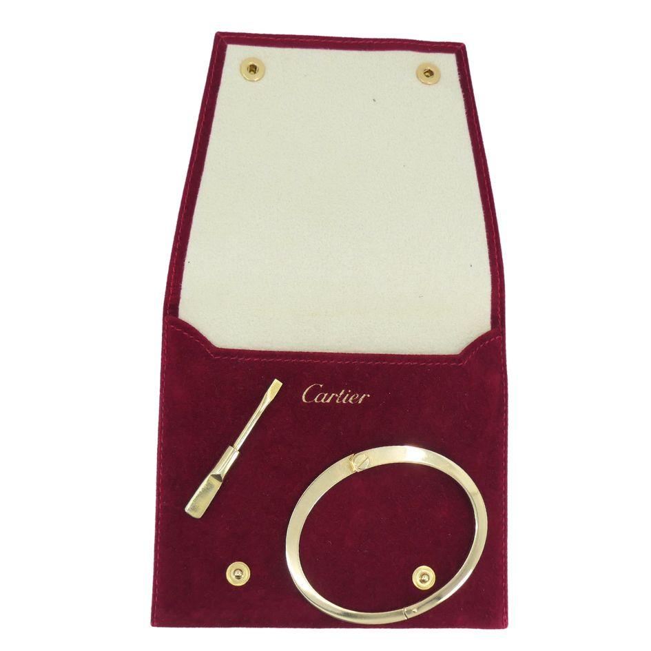 Ce bracelet Menotte de Cartier est réalisé en or jaune 18 carats et présente un motif à double vis sur le devant. Mesurant 7 pouces de circonférence intérieure avec une largeur de 1/2 pouce à son point le plus large, le bracelet est conçu pour un