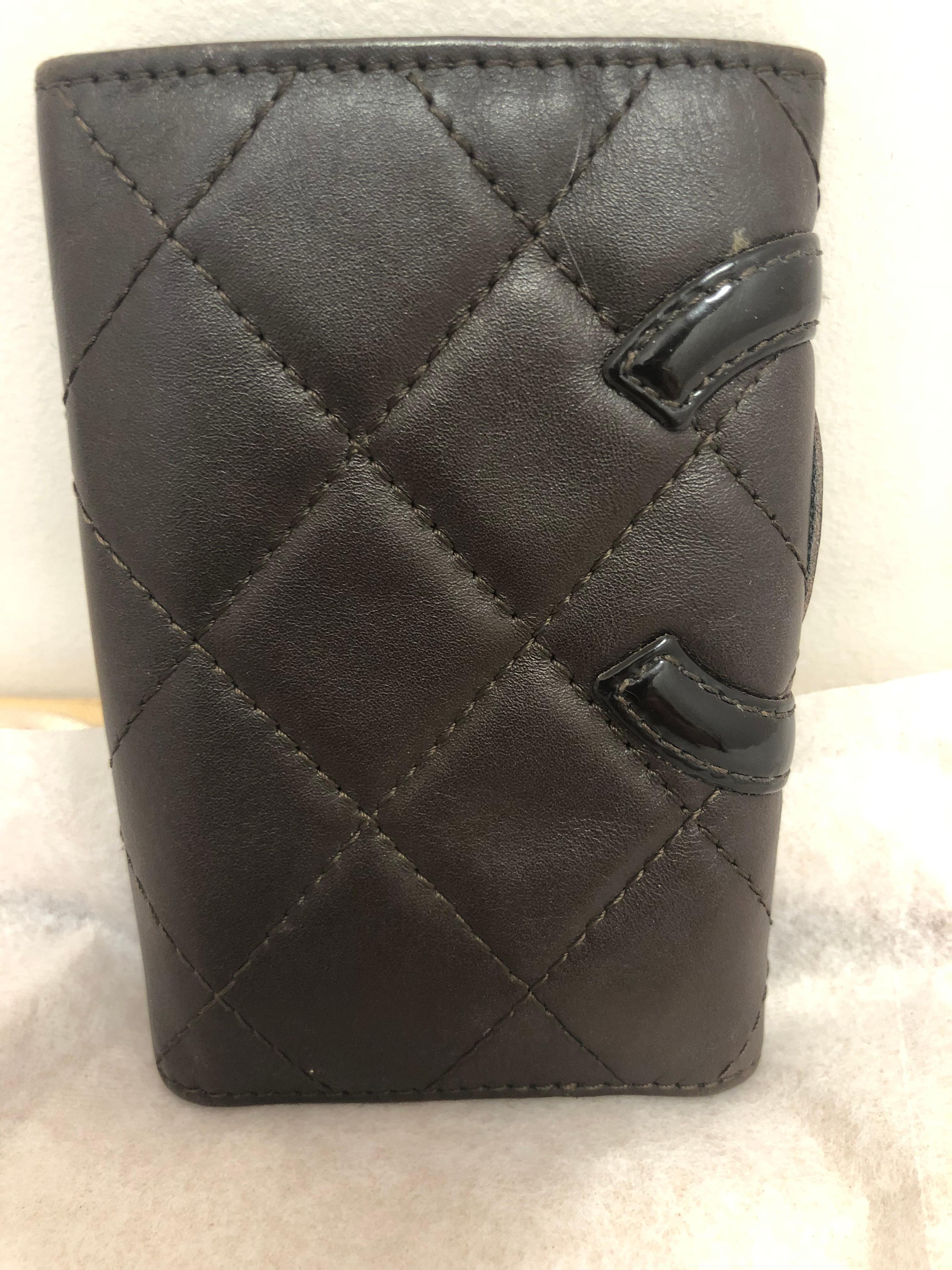 Chocolate brown w/black CC, this Chanel Cambon key holder is lined in orange and has a capacity for 6 keys; a slit pocket for credit cards, with one small slit for folded bills.

Made in Italy