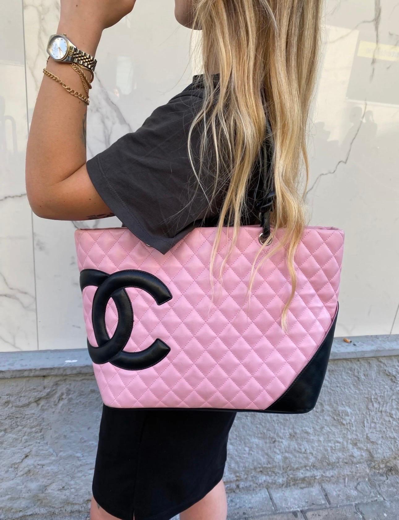 Chanel Cambon edition handbag in pink and black quilted leather with silver-tone hardware. It has a central opening with zip closure. The interior is lined with a soft black fabric and is equipped with two internal pockets, both with zip closure.