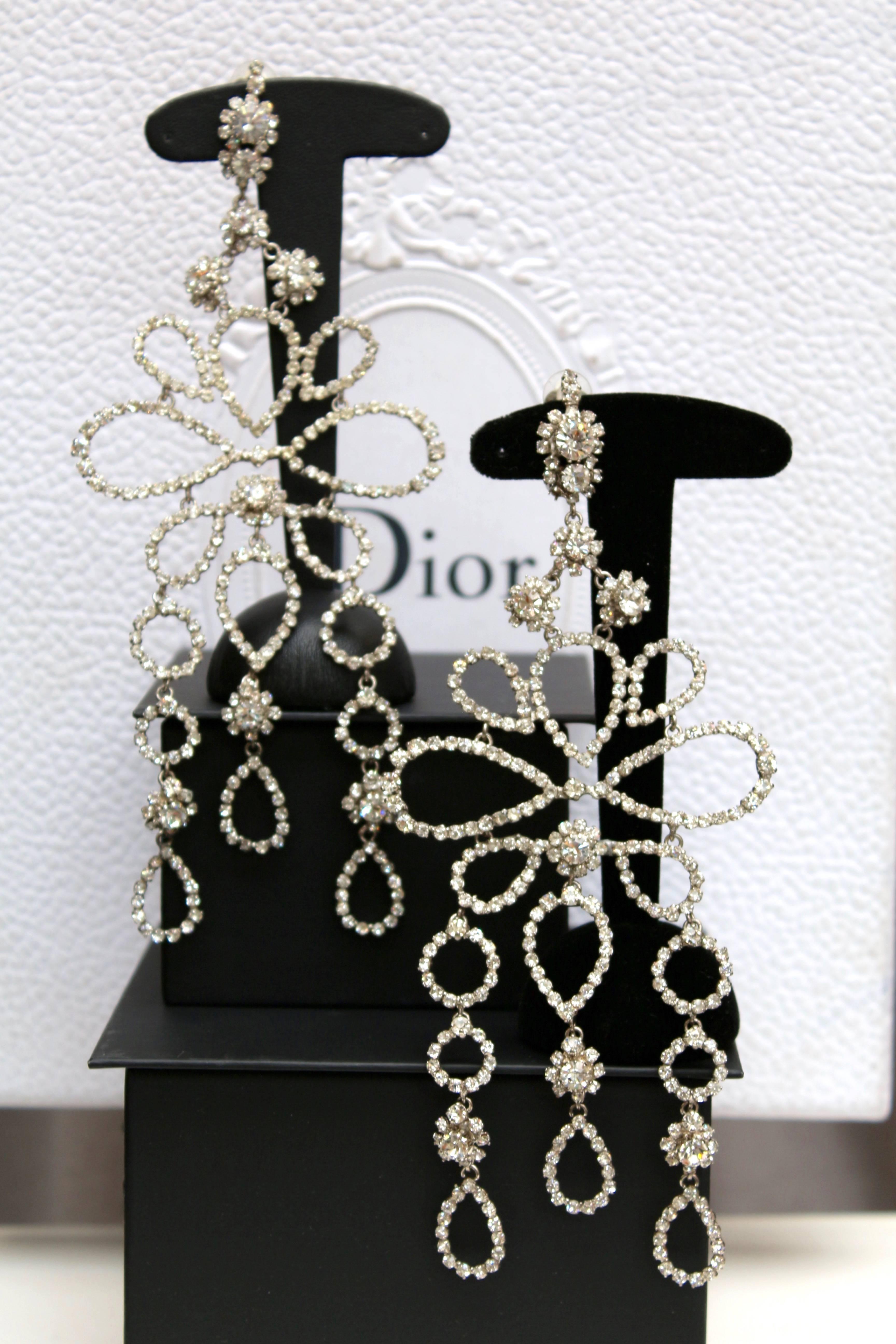 CHRISTIAN DIOR RUNWAY (Made in France) Magnificent spectacular pair of drop clip-on earrings composed of a gilded metal setting entirely paved with rhinestones in different size, in the shape of tear-drops or circles. A flower pattern decorates the