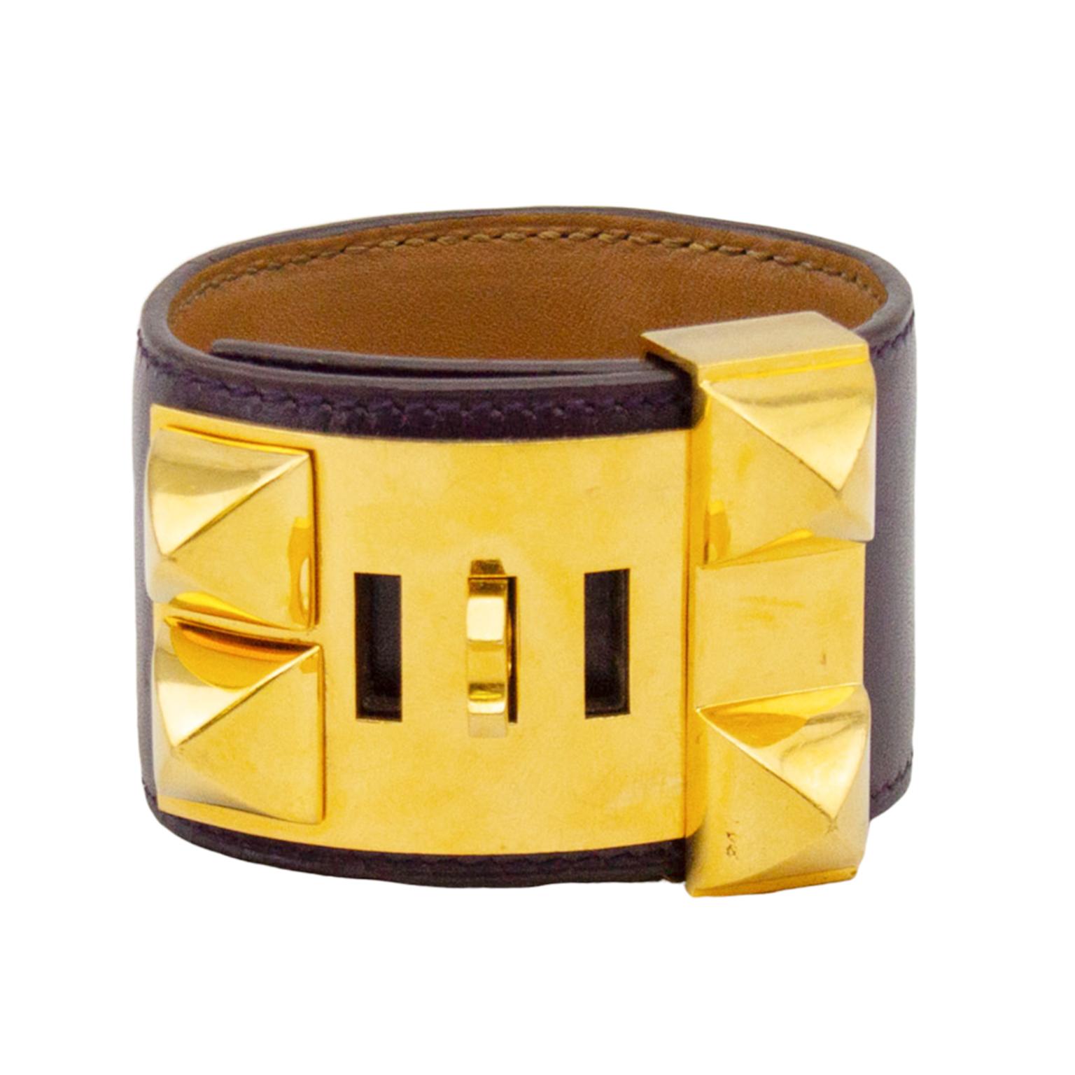 Classic and ever so collectable, the Hermes Collier de Chien bracelet cuff is a must have piece of jewelry. This deep, dark purple box leather cuff has gold tone hardware and can be adjusted to 4 different settings. The underside of the bracelet is