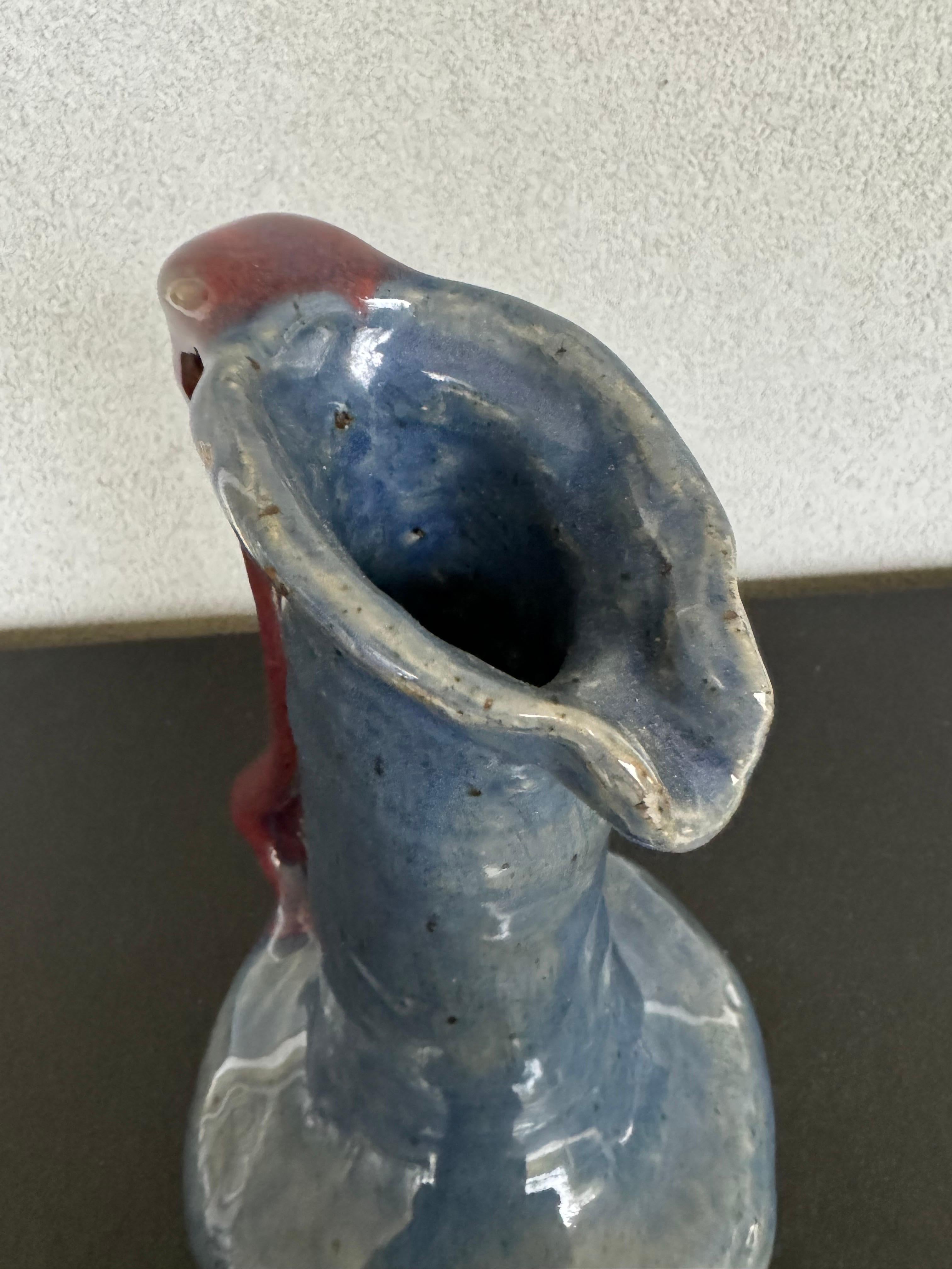 very unique blue glazed pottery pitcher with an organic shape handle in a burgundy color, it’s signed and dated on the bottom, looks like a student piece with its imperfections that make it even more adorable and a true one of kind piece of art