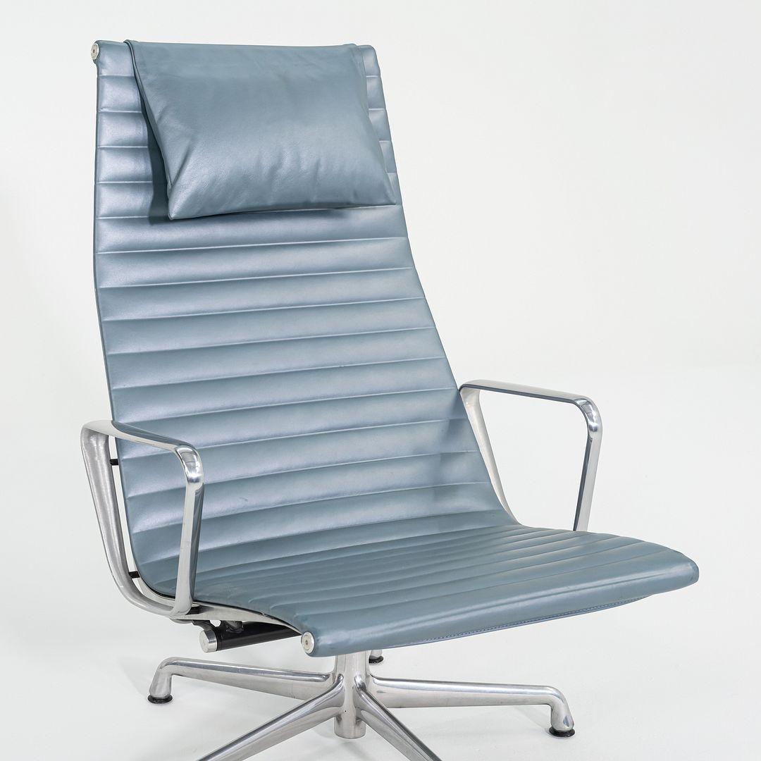 These are Eames Aluminum Group Reclining Lounge Chairs, Model EA338, originally designed by Charles and Ray Eames for Herman Miller in 1958. These particular examples date to 2005. They features blue leather upholstery, a five-star cast aluminum