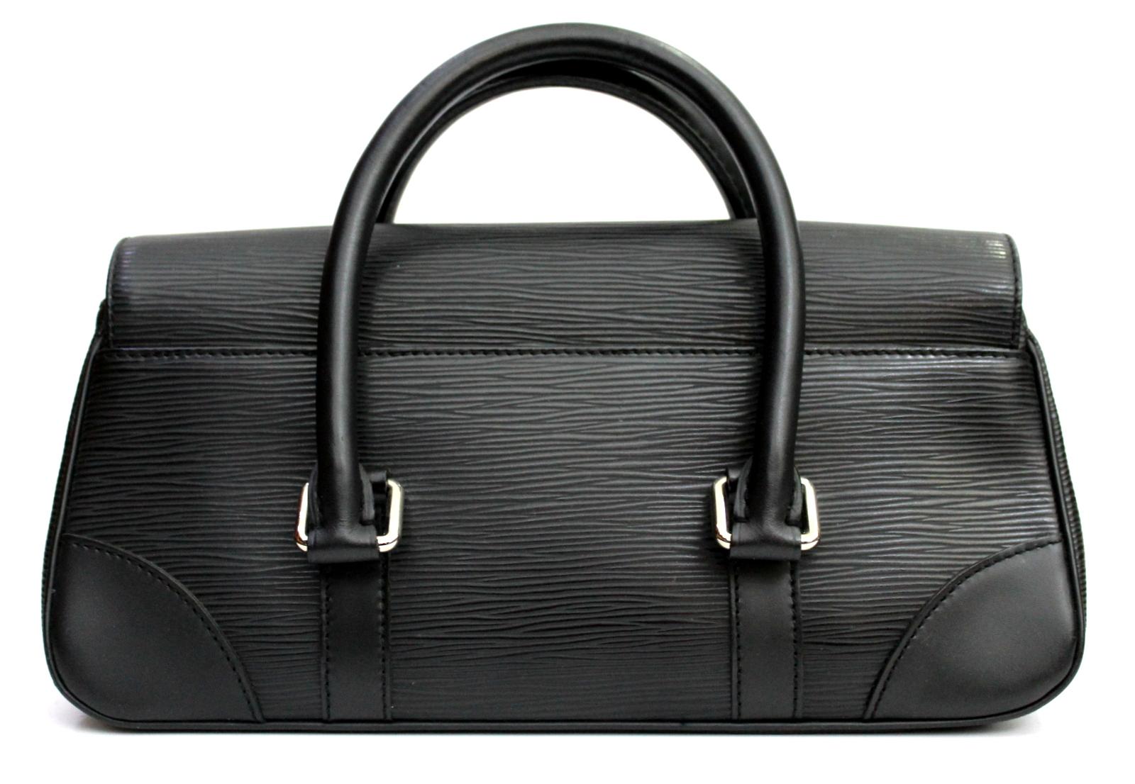 The Louis Vuitton Segur PM black bag is made of durable Epi leather with a magnificent silver metal lock that ensures the flap is closed. This size PM is the smallest size of the Segur family, which has two rigid handles and a back pocket. A