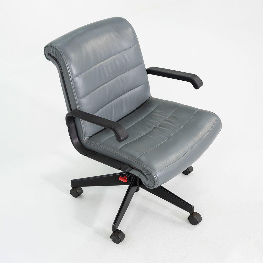 This is a Sapper Series Management Desk Chair, designed by Richard Sapper in 1979 and produced by Knoll. This particular example dates to 2005. This piece is comprised of a steel base with a pneumatic adjustable mechanism, and a seat upholstered in