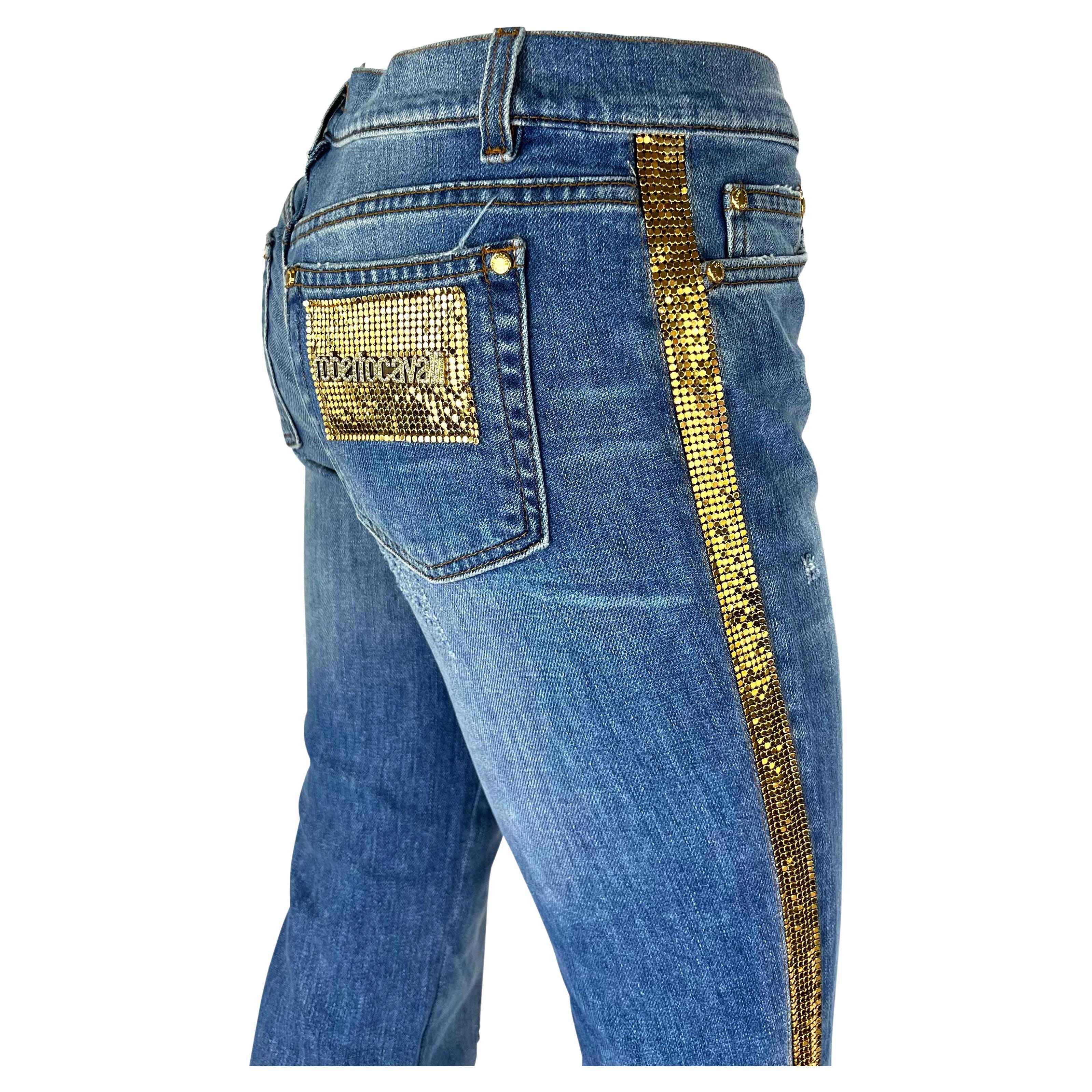 Je vous présente une paire de fabuleux jeans Roberto Cavalli. Datant de 2005, ce jean est l'exemple parfait du style de l'an 2000, avec une coupe taille basse et des accents métalliques en chaîne dorée. Ce jean est orné d'une chaîne métallique dorée