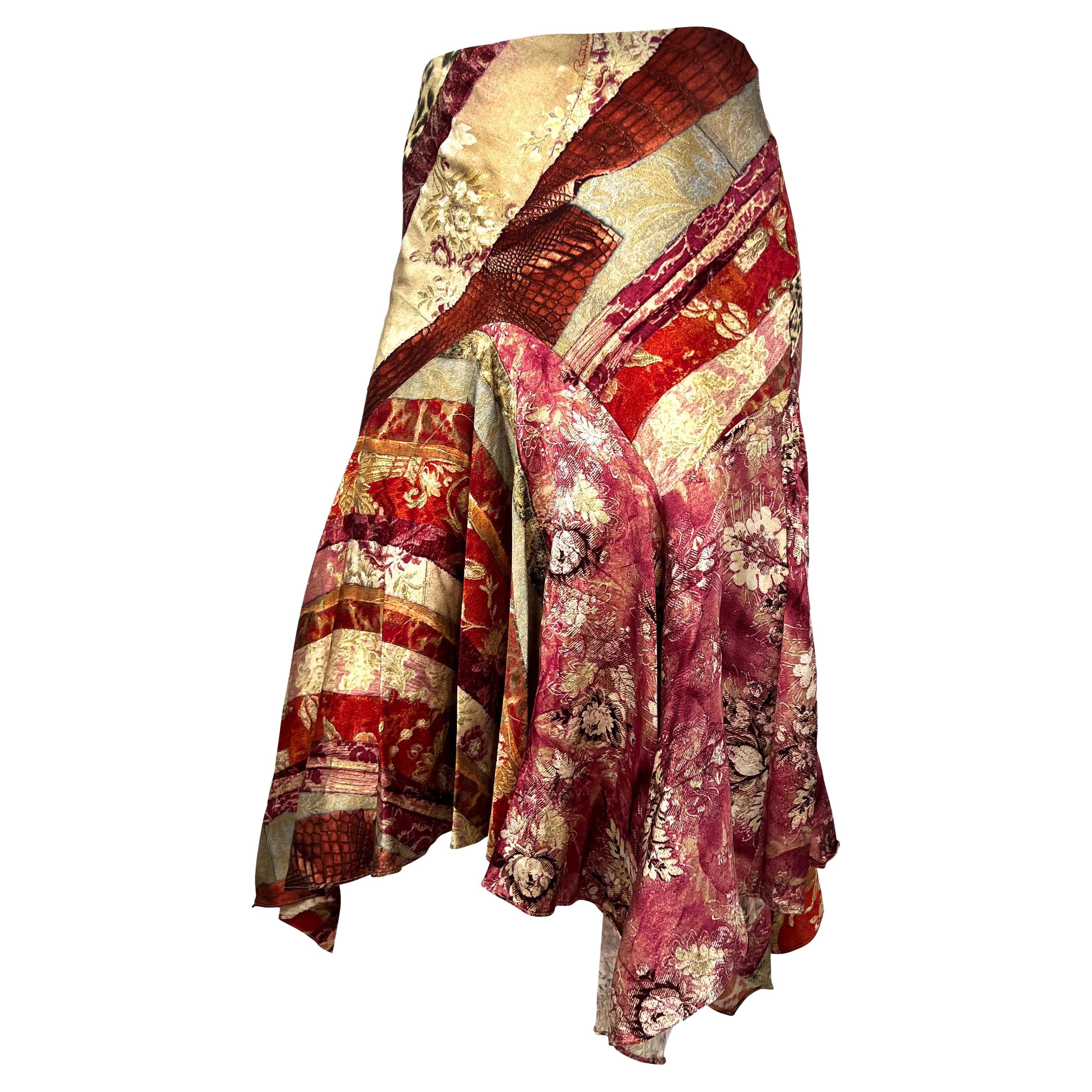 Presenting a silk flared skirt designed by Roberto Cavalli in 2005. This piece is covered in a detailed red and beige trompé-l'œil pattern depicting strips of contrasting materials and prints. Add this delightfully busy skirt to your closet or