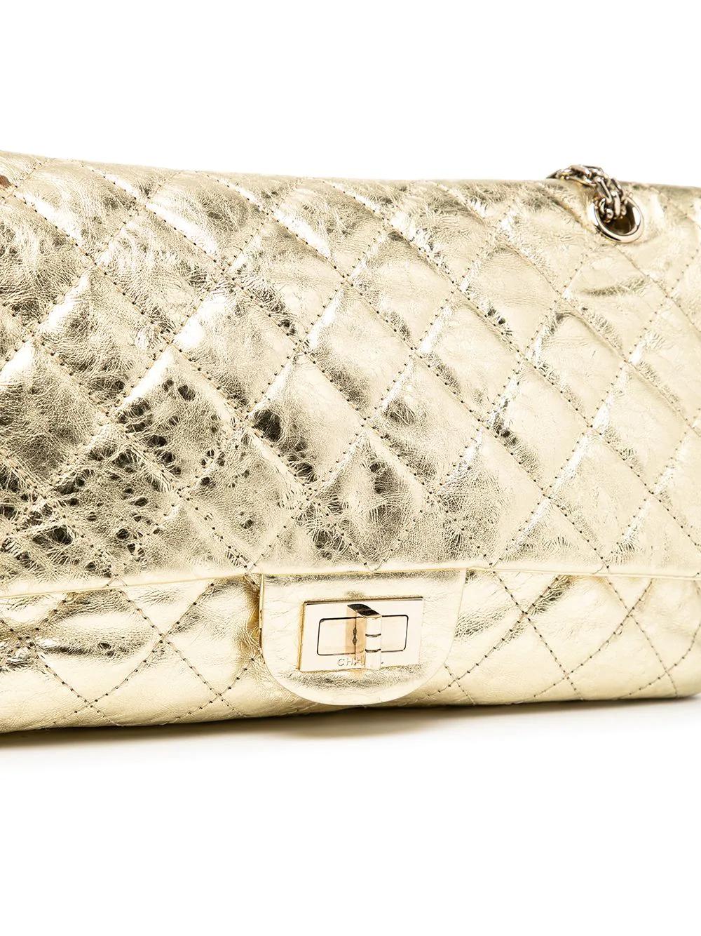 A true investment bag from Chanel that will stand the test of time. This gorgeous pre-owned Chanel Gold 2.55 Reissue Jumbo Flap Bag from 2006-2008 has been crafted from diamond-quilted gold-tone leather and features a mademoiselle turn-lock closure
