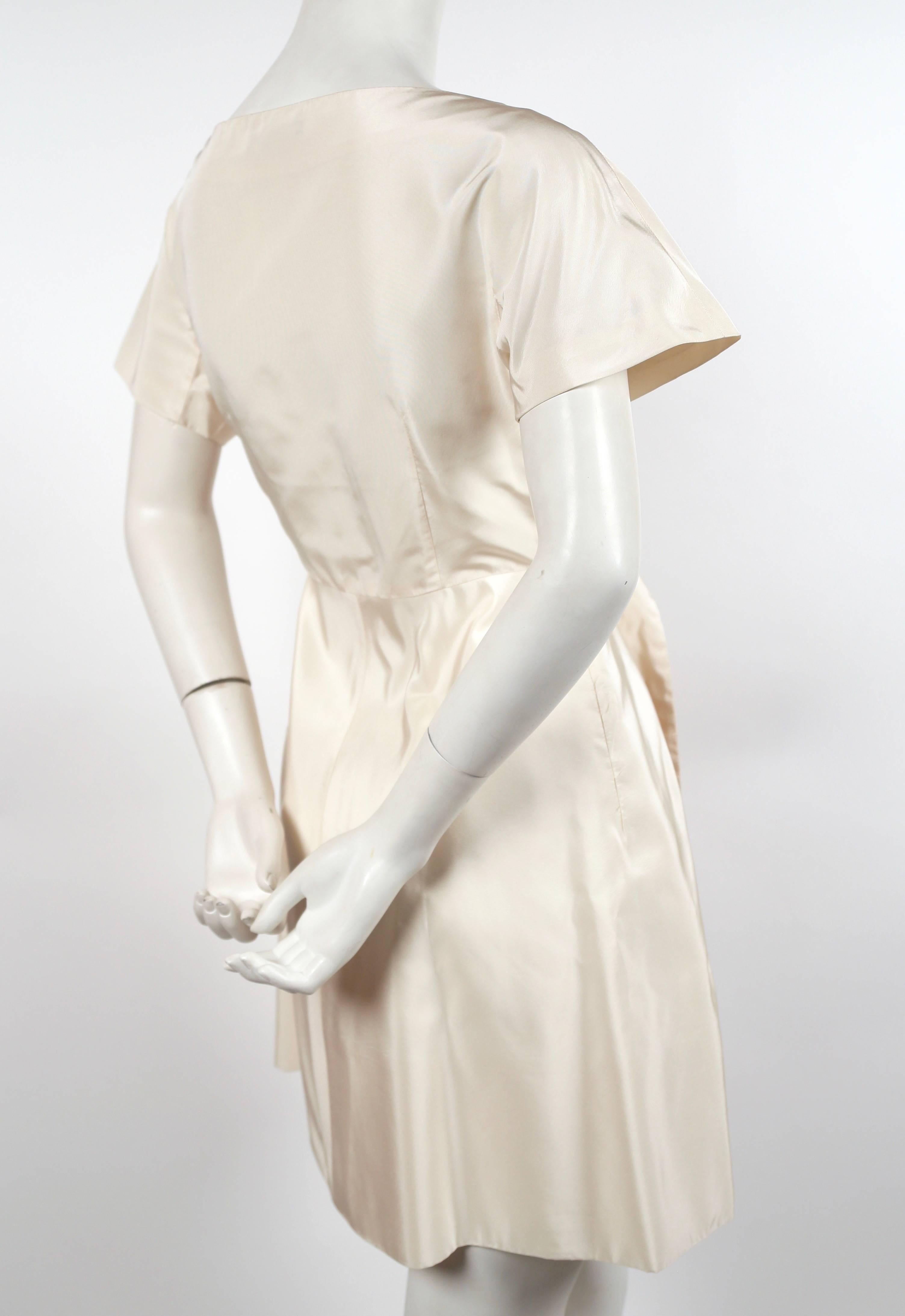 Cream silk dress with bow detail designed by Alexander McQueen dating to spring 2006 as seen on the runway. Italian size 42. Approximate measurements: bust 34